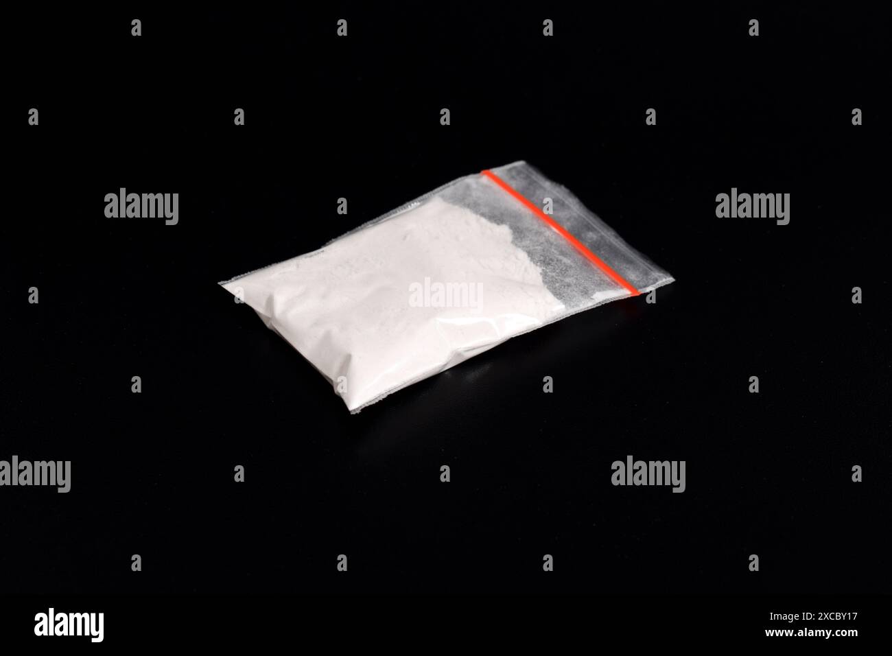 Cocaina in confezione di plastica isolata su sfondo nero. illustrazione di sostanze stupefacenti illegali, narcotici Foto Stock