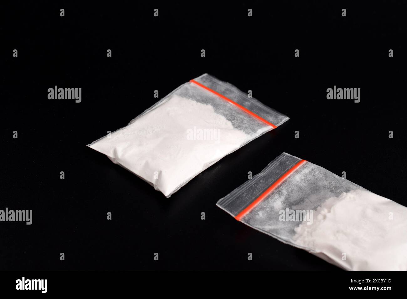 Cocaina in confezione di plastica isolata su sfondo nero. illustrazione di sostanze stupefacenti illegali, narcotici Foto Stock