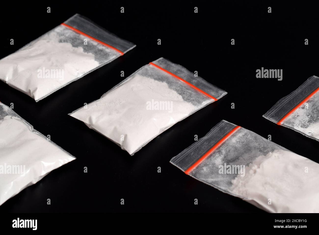 Cocaina in confezione di plastica isolata su sfondo nero. illustrazione di sostanze stupefacenti illegali, narcotici Foto Stock
