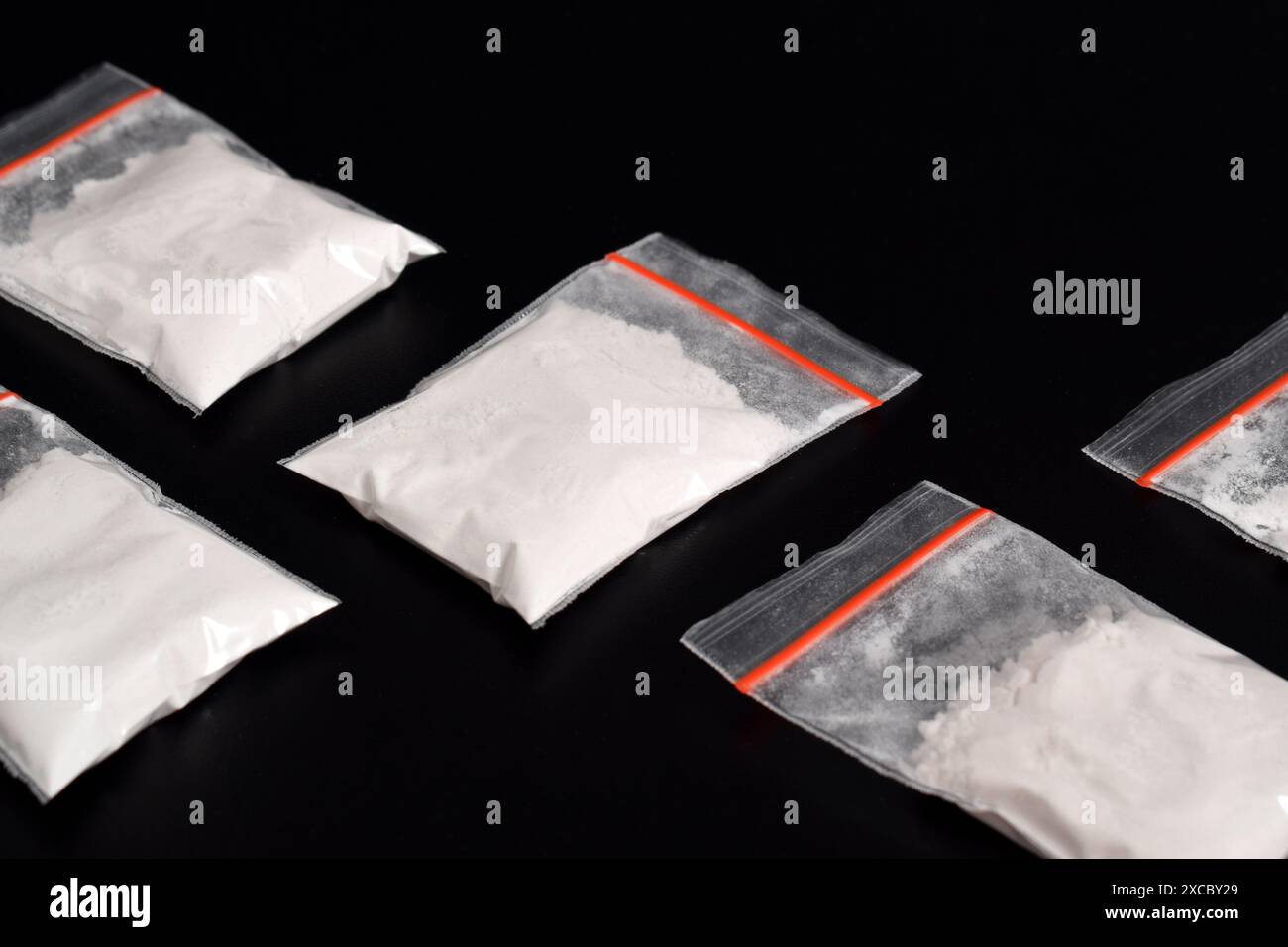 Cocaina in confezione di plastica isolata su sfondo nero. illustrazione di sostanze stupefacenti illegali, narcotici Foto Stock