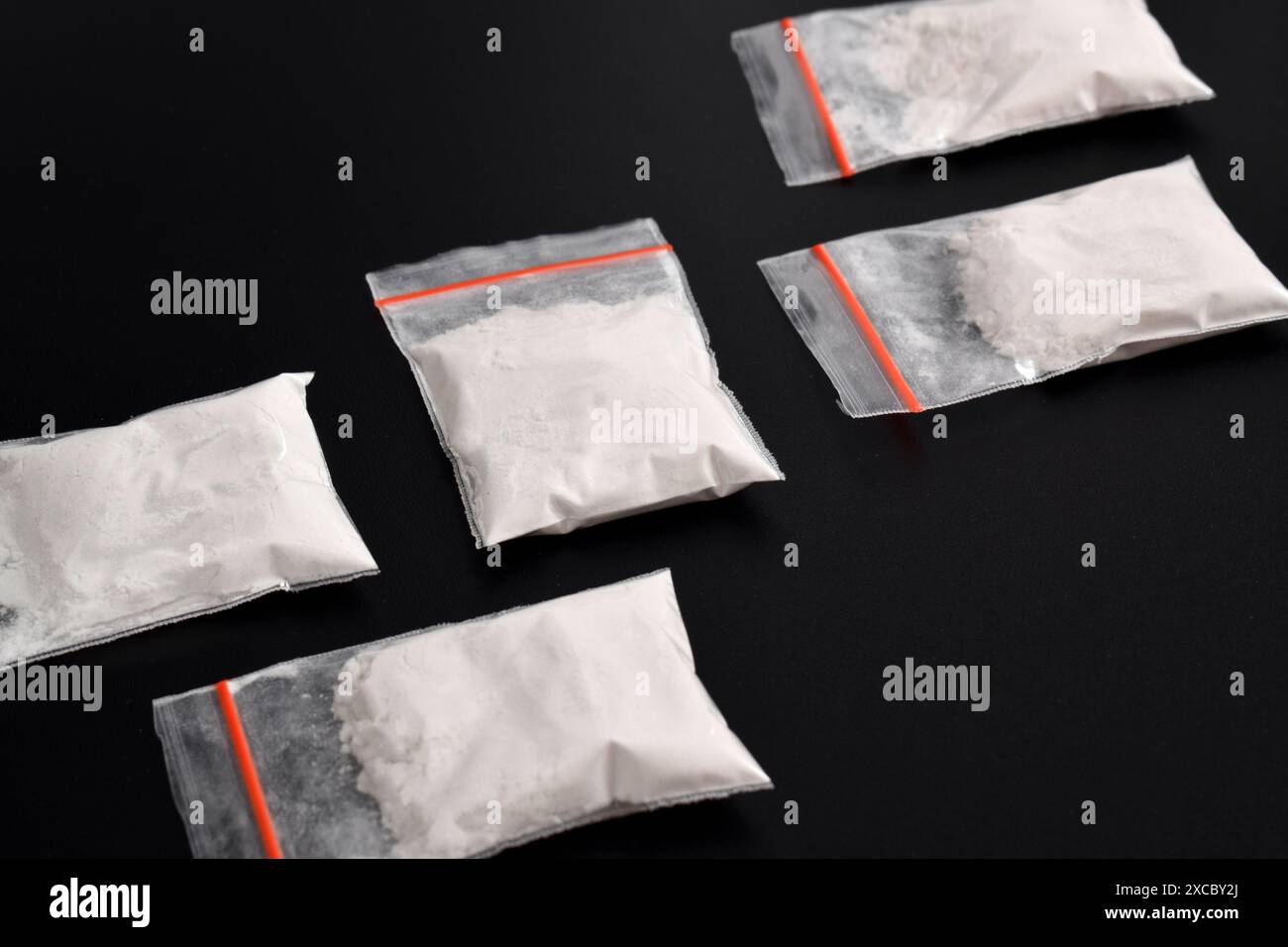 Cocaina in confezione di plastica isolata su sfondo nero. illustrazione di sostanze stupefacenti illegali, narcotici Foto Stock