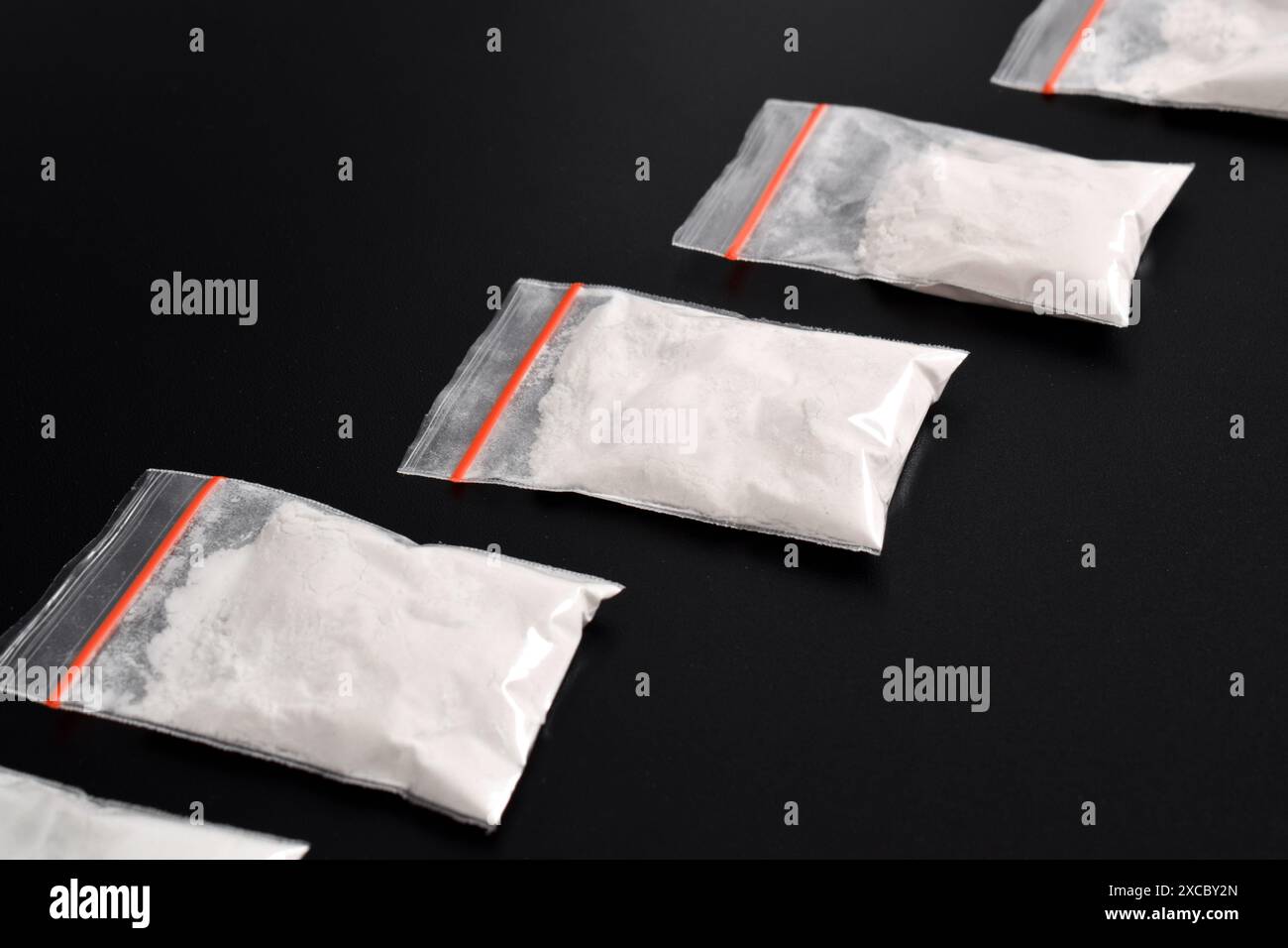 Cocaina in confezione di plastica isolata su sfondo nero. illustrazione di sostanze stupefacenti illegali, narcotici Foto Stock