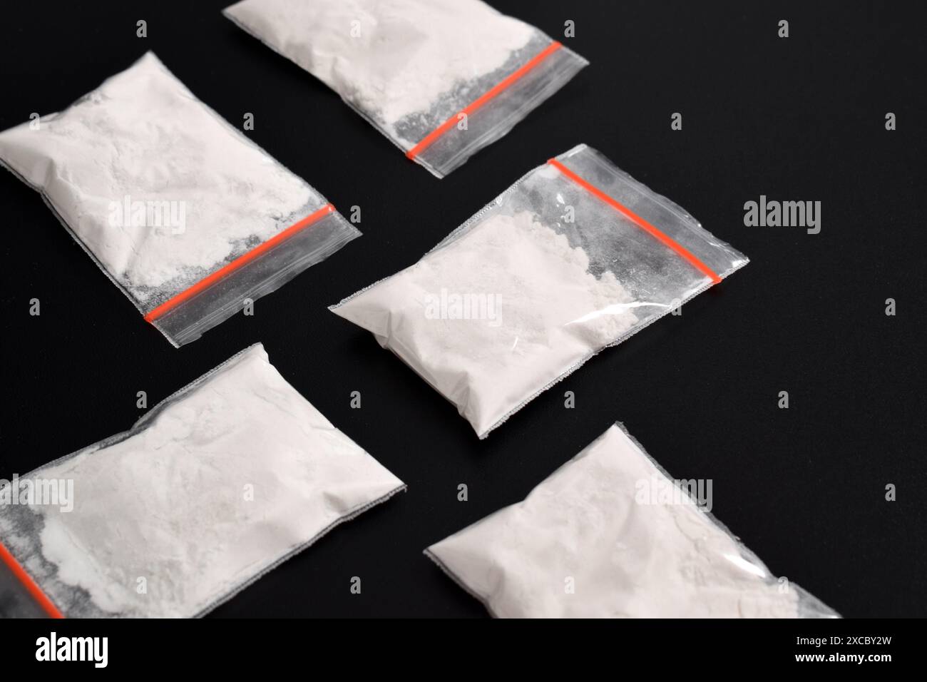 Cocaina in confezione di plastica isolata su sfondo nero. illustrazione di sostanze stupefacenti illegali, narcotici Foto Stock