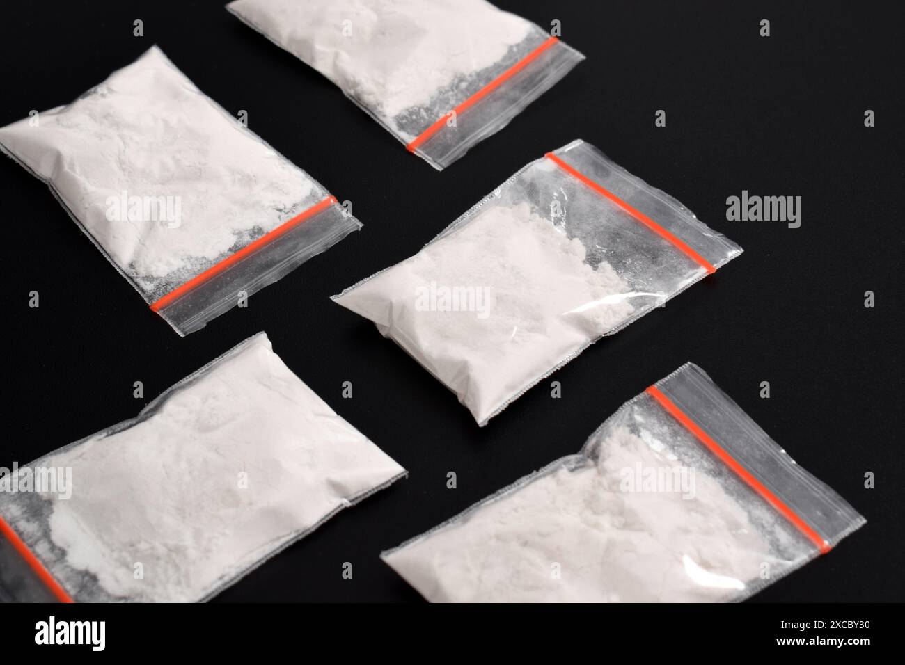 Cocaina in confezione di plastica isolata su sfondo nero. illustrazione di sostanze stupefacenti illegali, narcotici Foto Stock