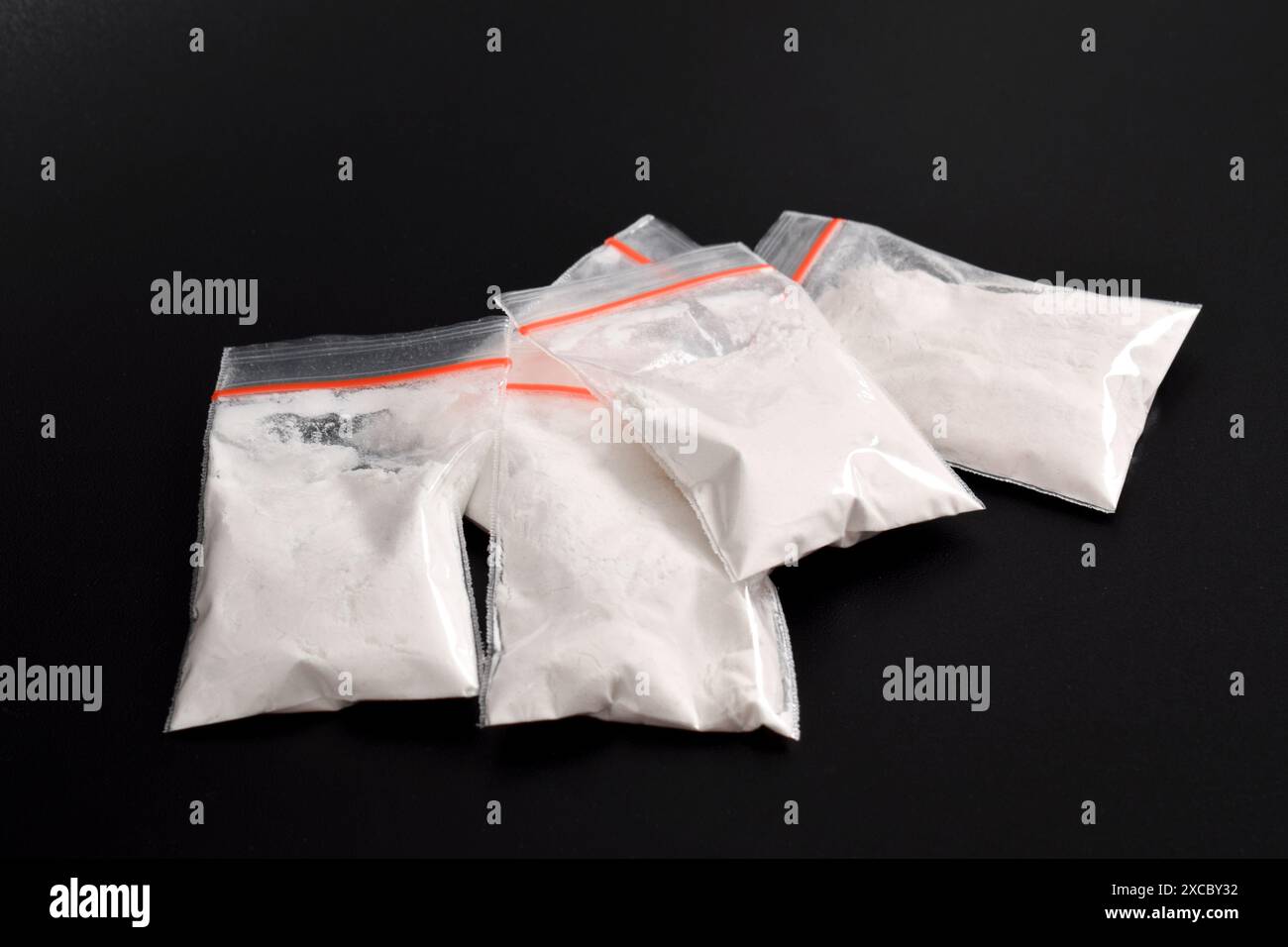 Cocaina in confezione di plastica isolata su sfondo nero. illustrazione di sostanze stupefacenti illegali, narcotici Foto Stock
