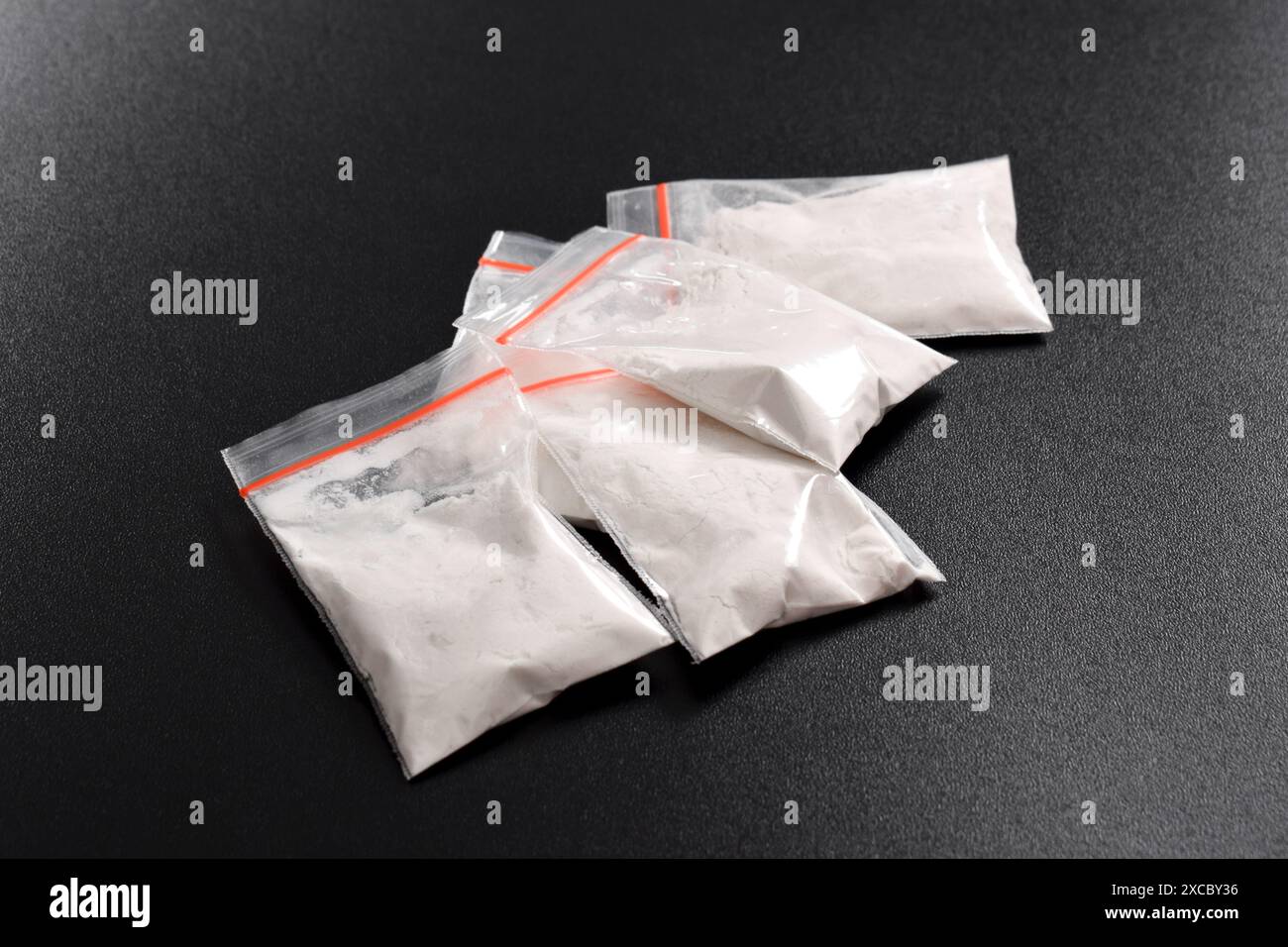 Cocaina in confezione di plastica isolata su sfondo nero. illustrazione di sostanze stupefacenti illegali, narcotici Foto Stock