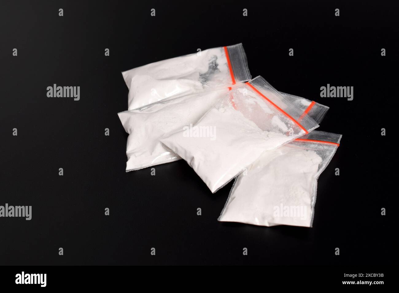 Cocaina in confezione di plastica isolata su sfondo nero. illustrazione di sostanze stupefacenti illegali, narcotici Foto Stock
