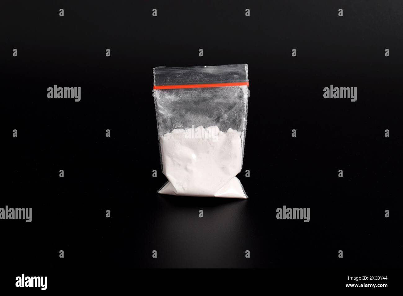 Cocaina in confezione di plastica isolata su sfondo nero. illustrazione di sostanze stupefacenti illegali, narcotici Foto Stock
