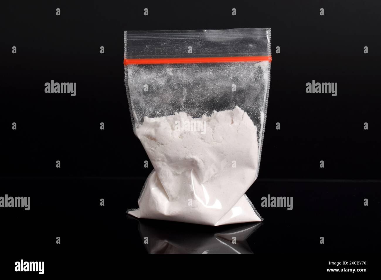 Cocaina in confezione di plastica isolata su sfondo nero. illustrazione di sostanze stupefacenti illegali, narcotici Foto Stock