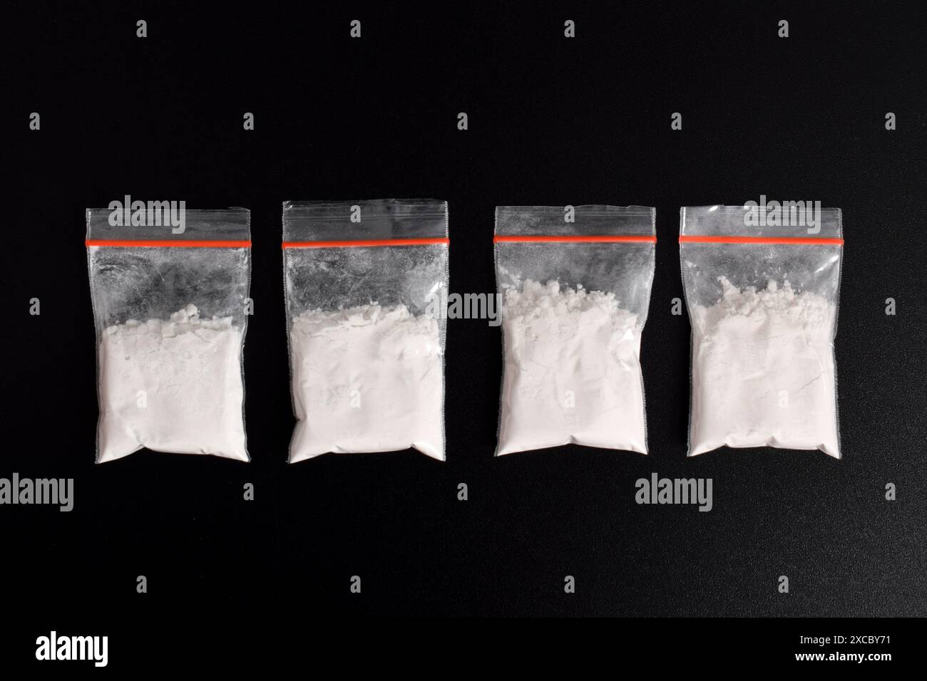 Cocaina in confezione di plastica isolata su sfondo nero. illustrazione di sostanze stupefacenti illegali, narcotici Foto Stock
