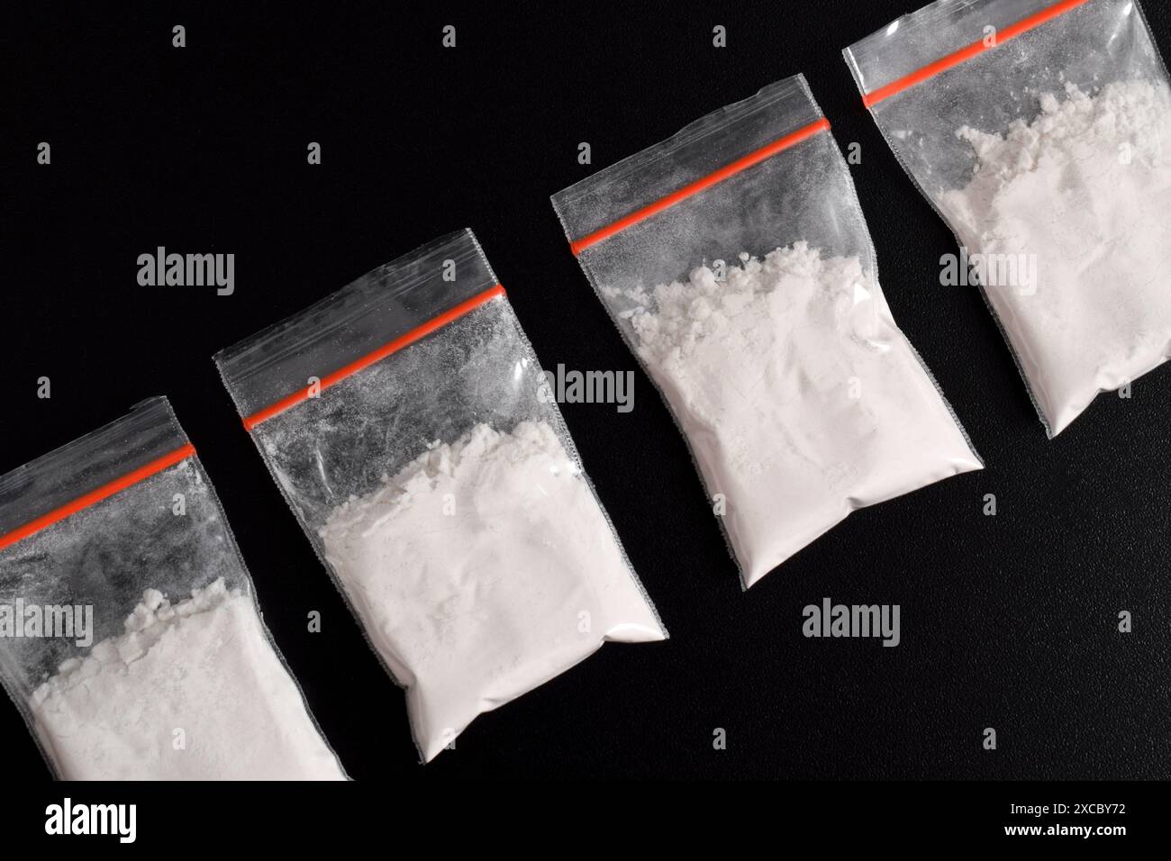 Cocaina in confezione di plastica isolata su sfondo nero. illustrazione di sostanze stupefacenti illegali, narcotici Foto Stock