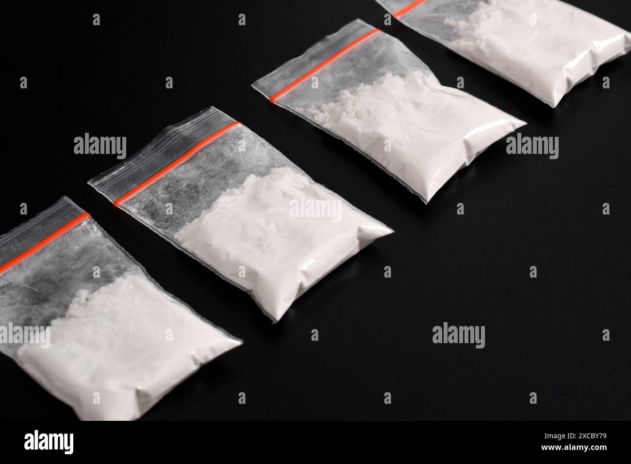 Cocaina in confezione di plastica isolata su sfondo nero. illustrazione di sostanze stupefacenti illegali, narcotici Foto Stock