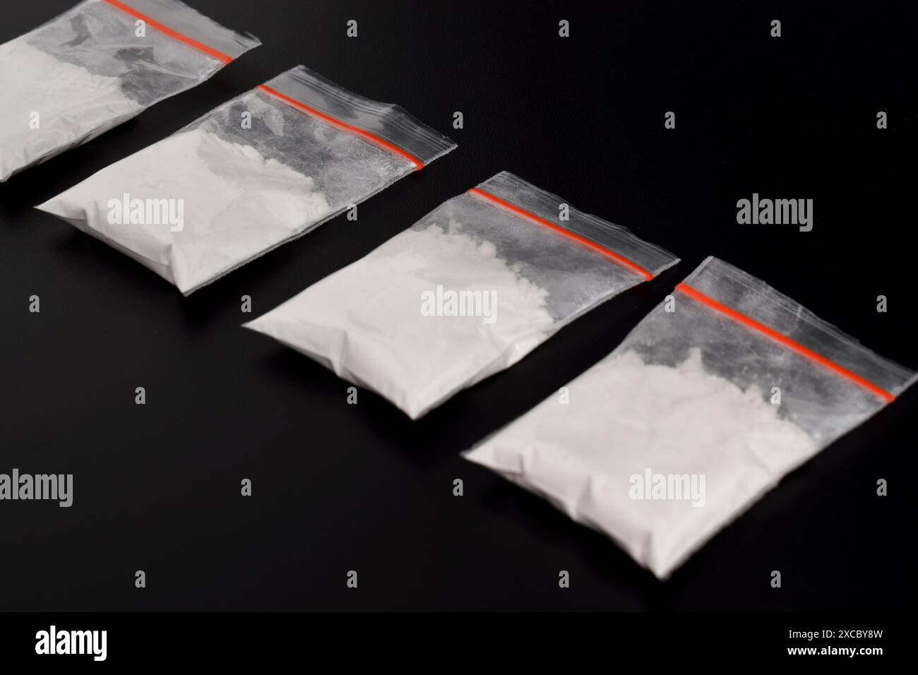 Cocaina in confezione di plastica isolata su sfondo nero. illustrazione di sostanze stupefacenti illegali, narcotici Foto Stock