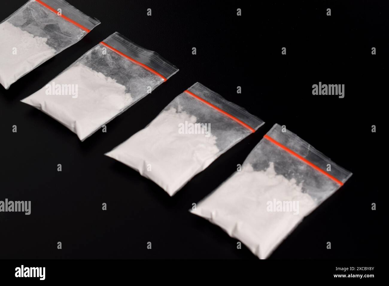 Cocaina in confezione di plastica isolata su sfondo nero. illustrazione di sostanze stupefacenti illegali, narcotici Foto Stock