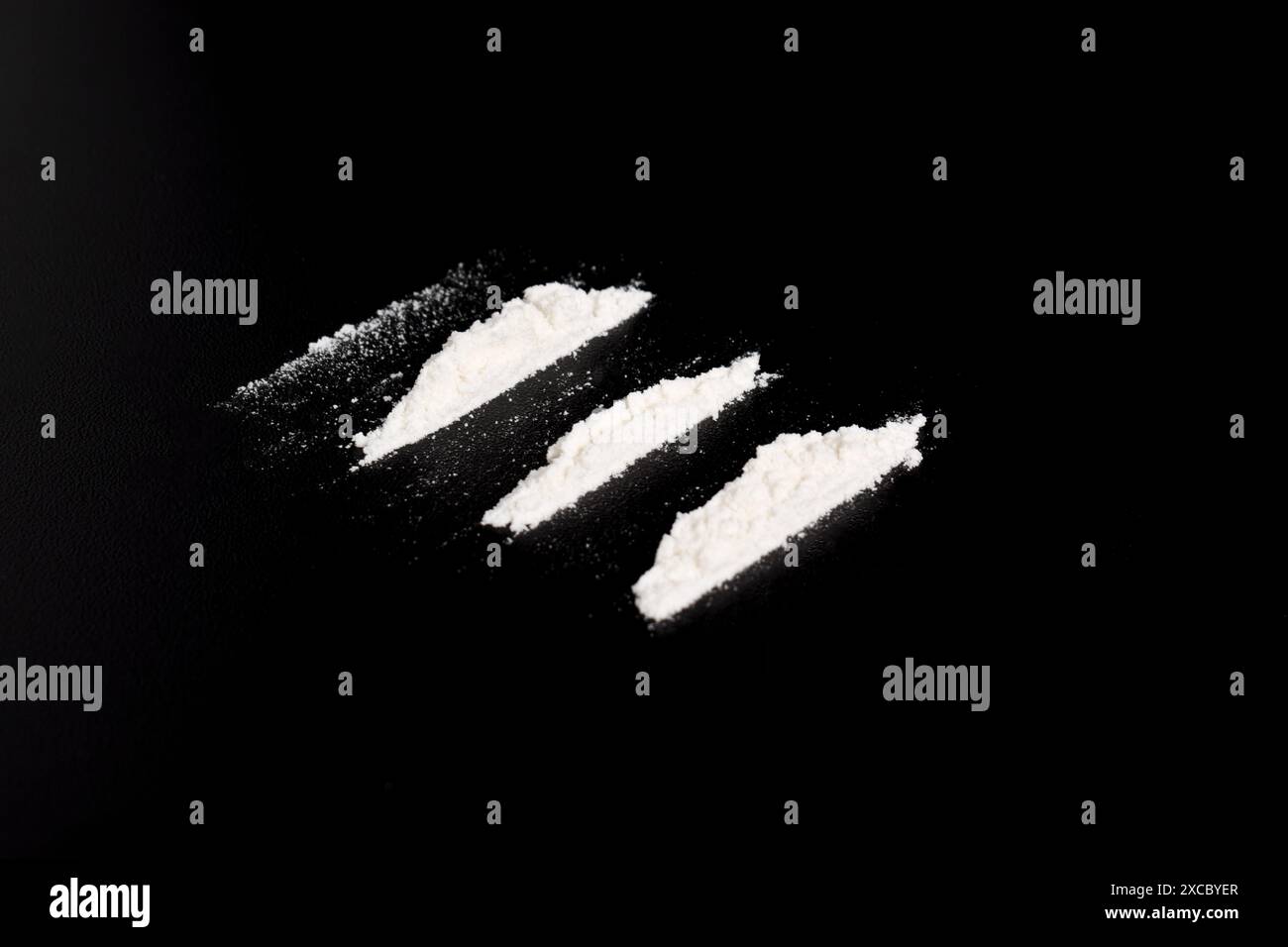 Polvere di cocaina in tre linee isolata su sfondo nero. illustrazione di sostanze stupefacenti illegali Foto Stock