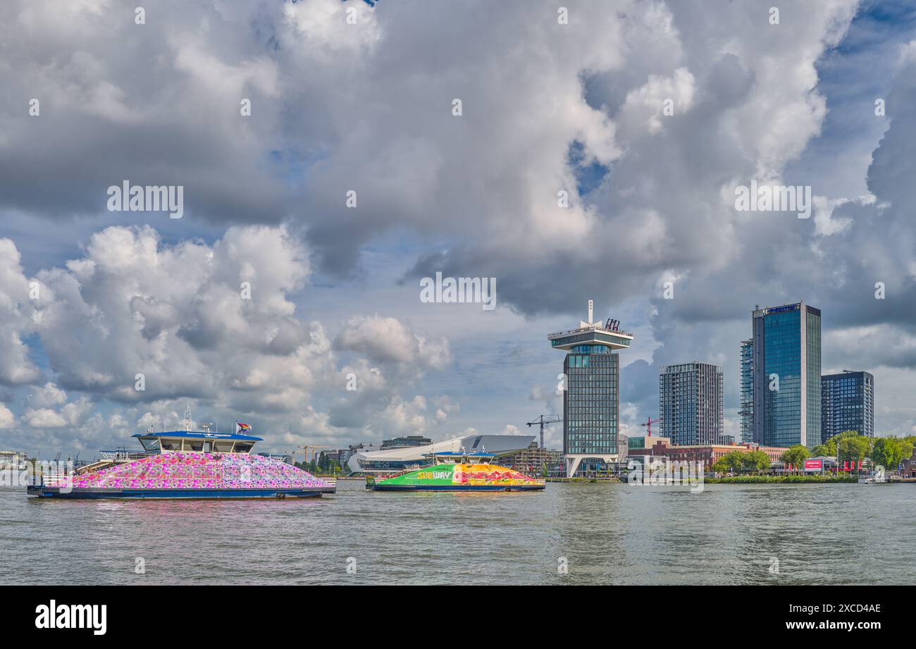 Amsterdam, Olanda - 9 agosto 2023: Le torri a nord viste dalla stazione centrale con i traghetti sul fiume IJ Foto Stock