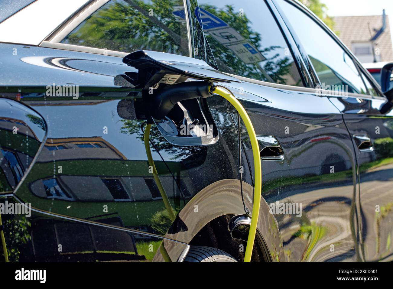 L'auto elettrica è in carica, primo piano del cavo collegato Foto Stock