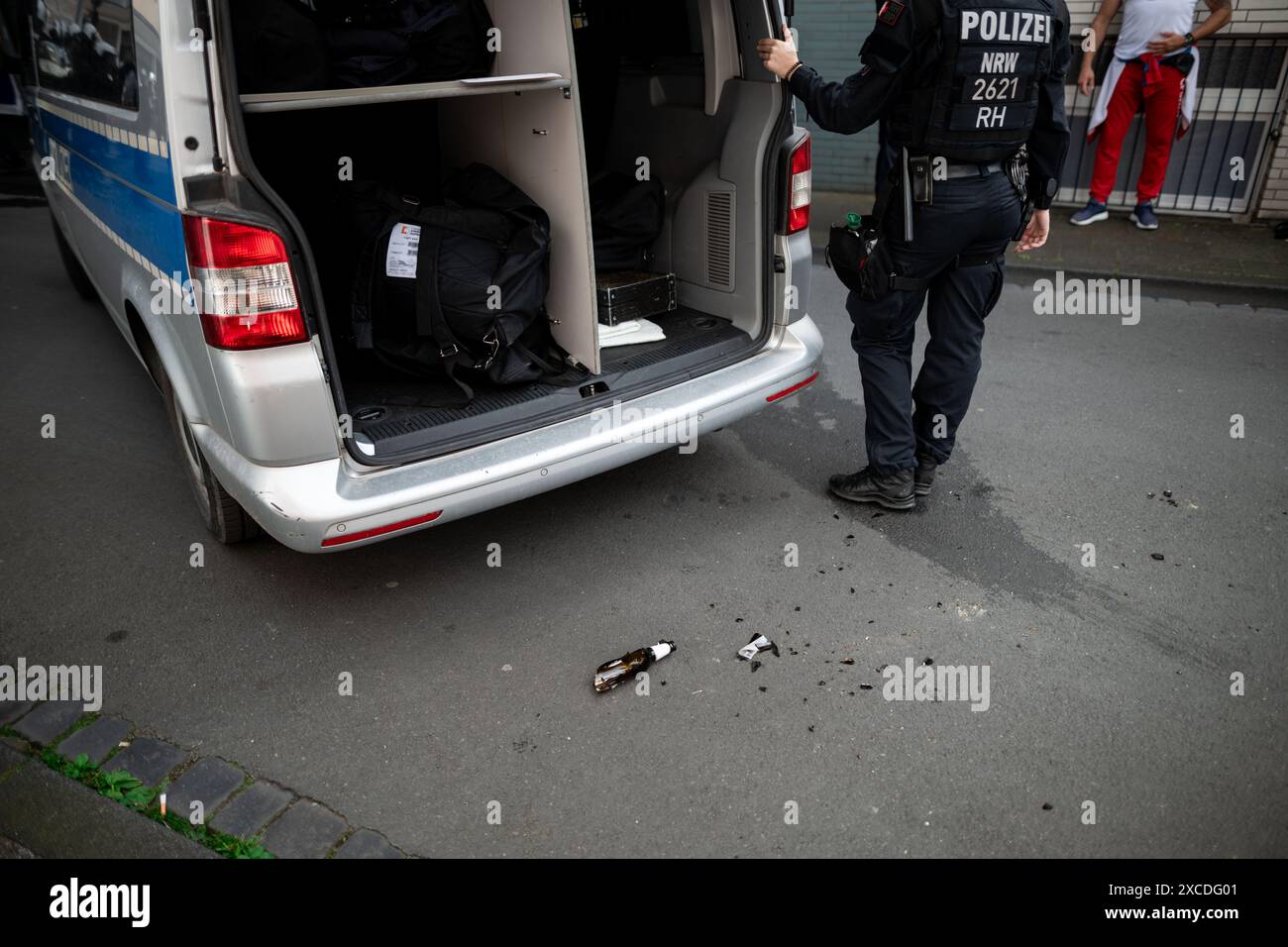 Gelsenkirchen, Germania. 16 giugno 2024. Calcio: Campionato europeo, Serbia - Inghilterra, turno preliminare, gruppo C, partita 1. Una bottiglia di birra rotta giace per terra di fronte a un'auto della polizia dopo le rivolte nel centro di Gelsenkirchen. Credito: Fabian Strauch/dpa - ATTENZIONE: I nomi sulla nota sulla valigia sono stati apposti per motivi di privacy/dpa/Alamy Live News Foto Stock