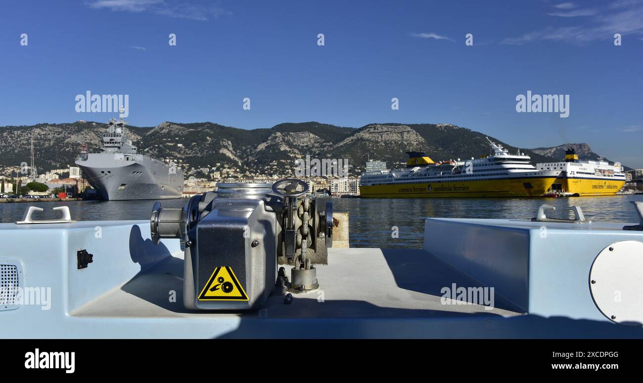 La portaerei di elicotteri e mezzi da sbarco Tonnerre della marina francese e i traghetti corsica sono situati nel porto di Tolone Foto Stock