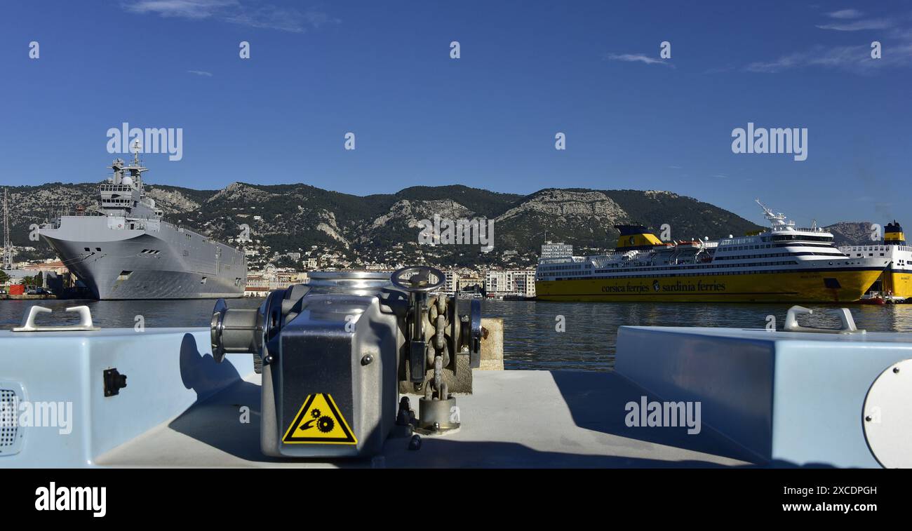 La portaerei di elicotteri e mezzi da sbarco Tonnerre della marina francese e i traghetti corsica sono situati nel porto di Tolone Foto Stock