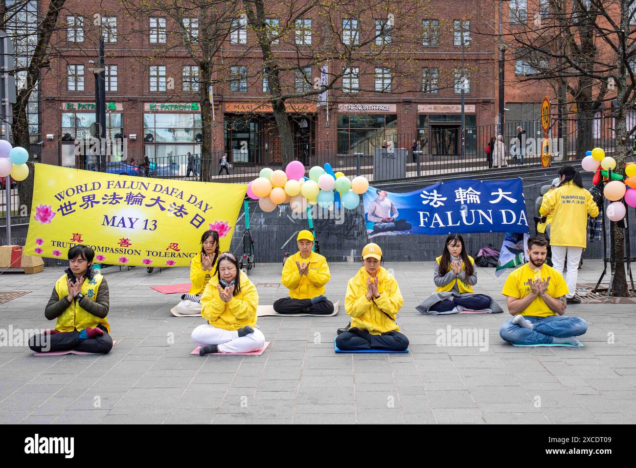 Il Falun Gong aderisce alla meditazione in posizione seduta di loto nel distretto di Kamppi a Helsinki, Finlandia Foto Stock