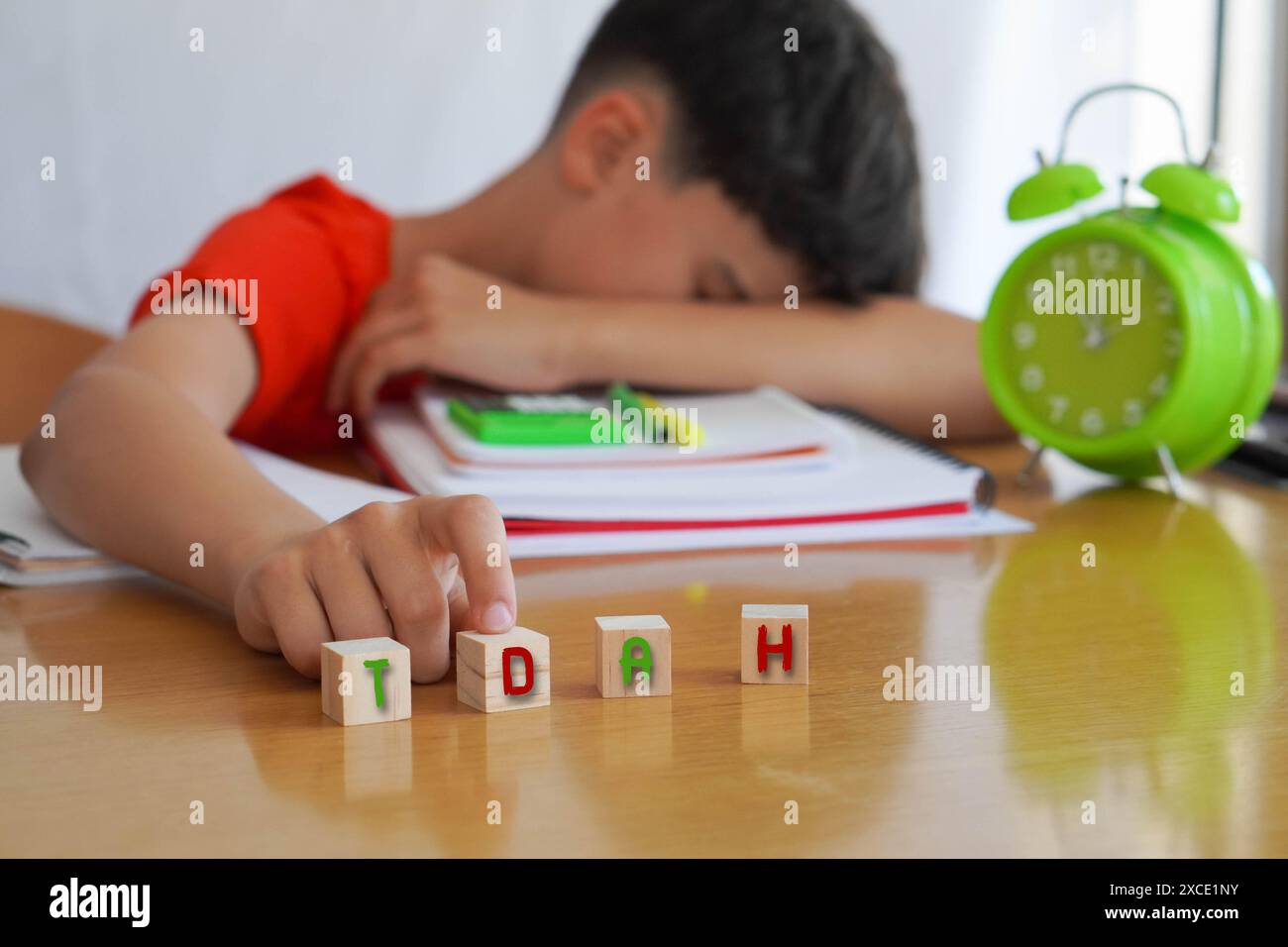Bambino circondato da libri e quaderni frustrato, con l'acronimo ADHD, rappresenta la malattia disturbo da deficit di attenzione e le difficoltà che esso e Foto Stock