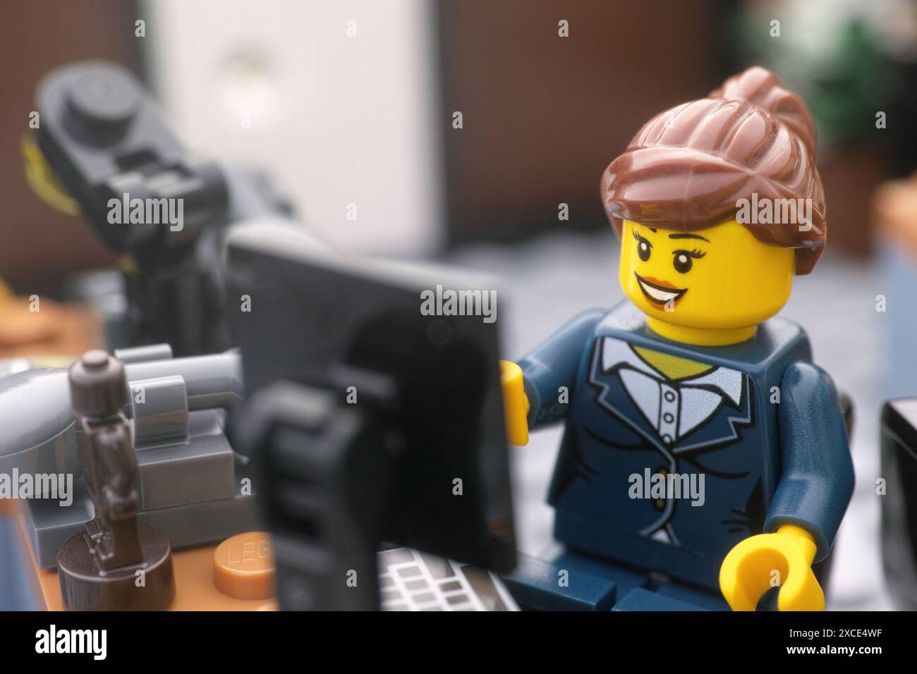 Tambov, Federazione Russa - 16 giugno 2024 Una minifigura d'affari Lego seduta e che lavora dietro un computer in un ufficio. Primo piano. Foto Stock