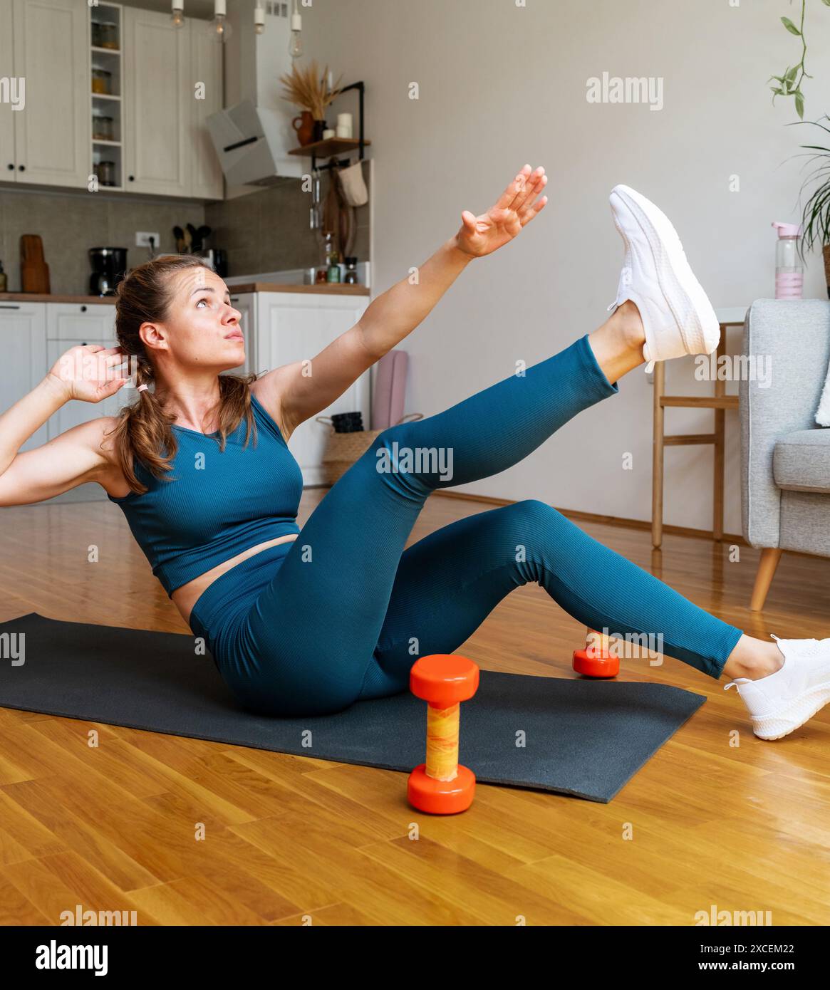 Cura del corpo e stile di vita sano. Fitness a casa. Atletica giovane donna in abbigliamento sportivo che fa l'allenamento ab a casa. Foto Stock