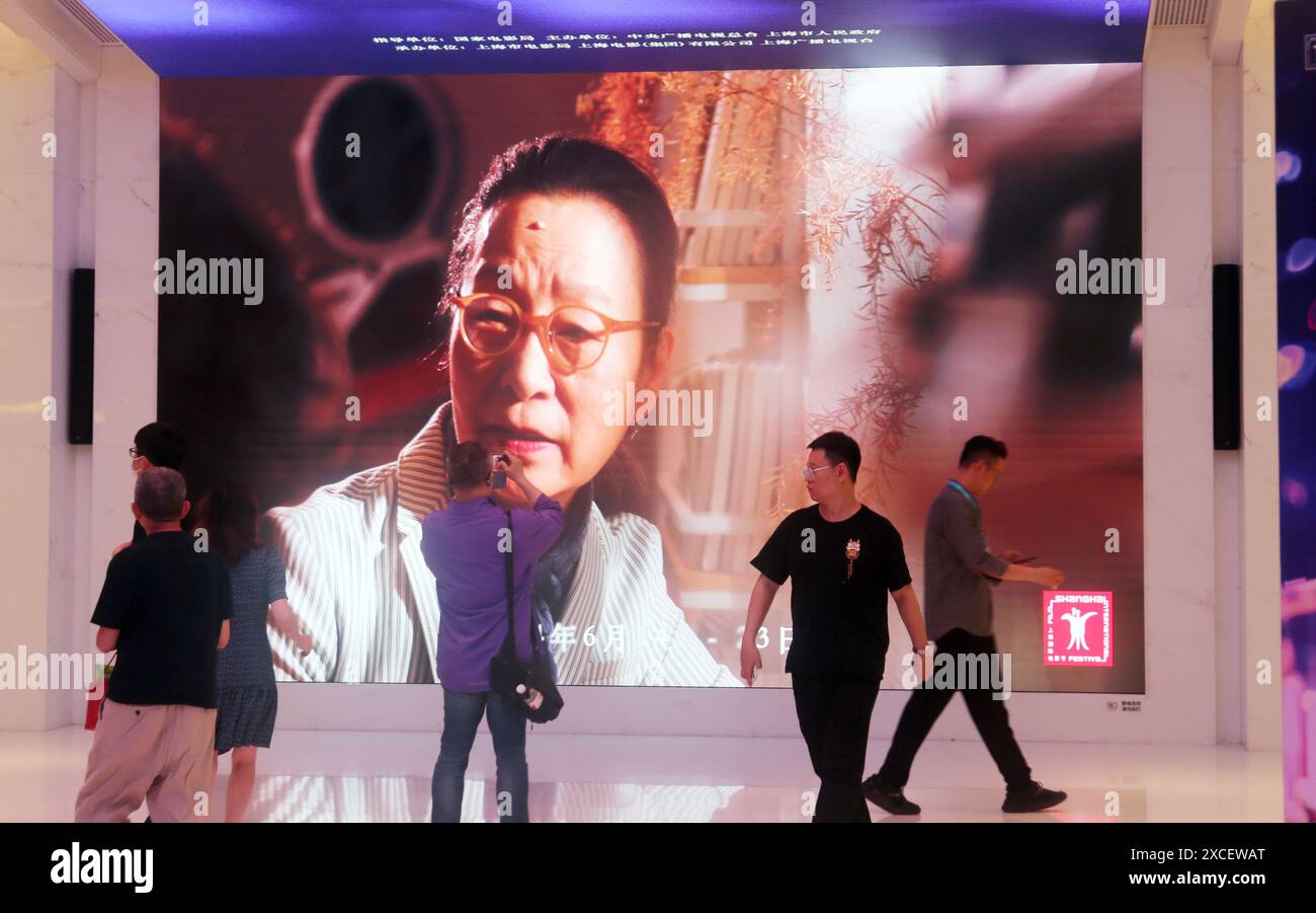 SHANGHAI, CINA - 15 GIUGNO 2024 - i fan del cinema passano un film promozionale dello Shanghai International Film Festival mostrato su un grande schermo a Shanghai Cine Foto Stock