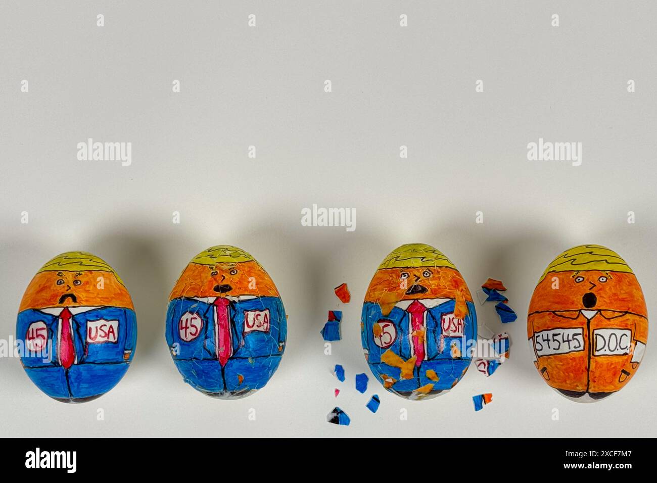 Disegni cartoonici sulle uova crepa e sbuccia, mostrando il 45° presidente delle "uova" che si trasforma da candidato a detenuto in tuta arancione. Foto Stock