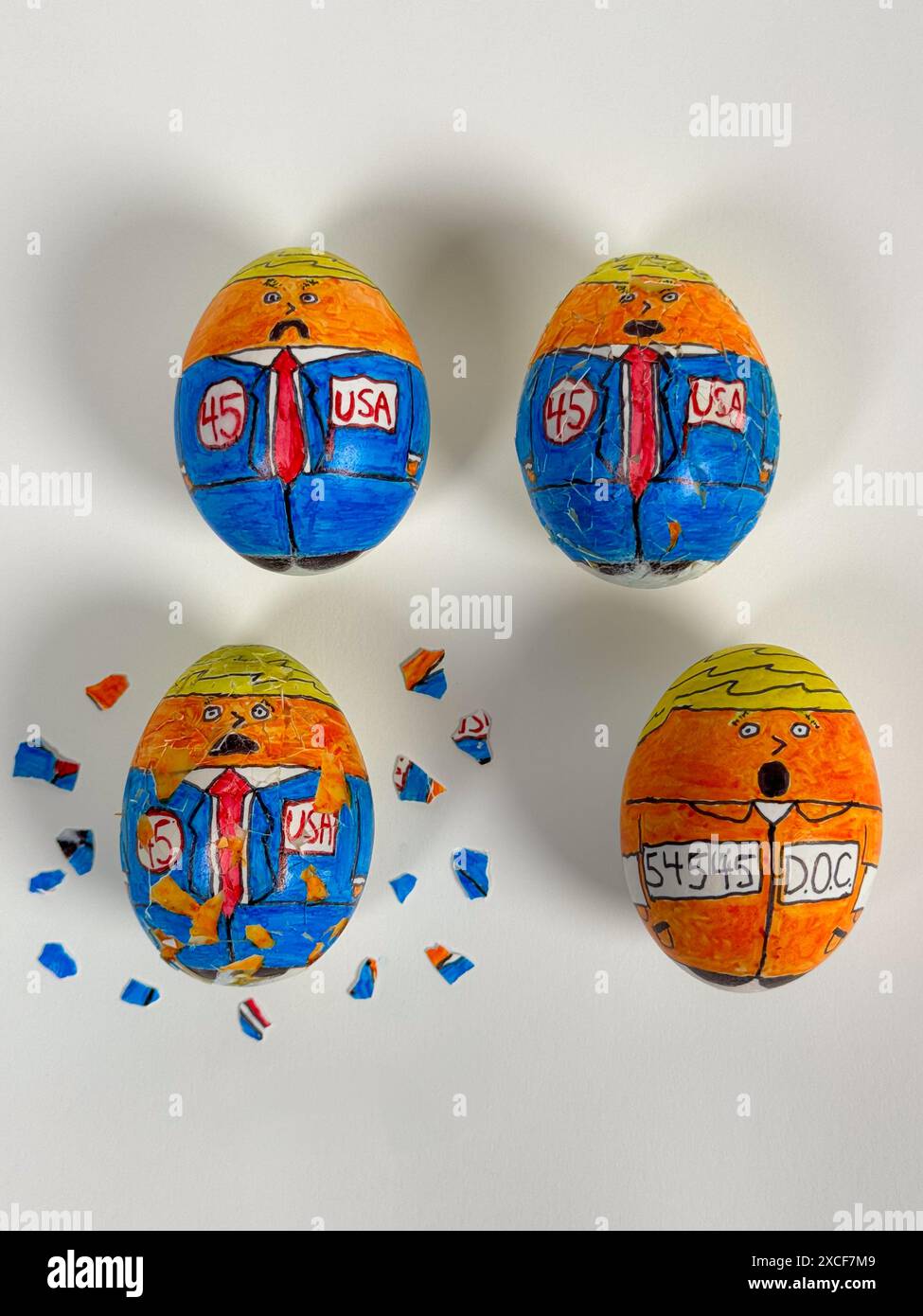 Disegni cartoonici sulle uova crepa e sbuccia, mostrando il 45° presidente delle "uova" che si trasforma da candidato a detenuto in tuta arancione. Foto Stock