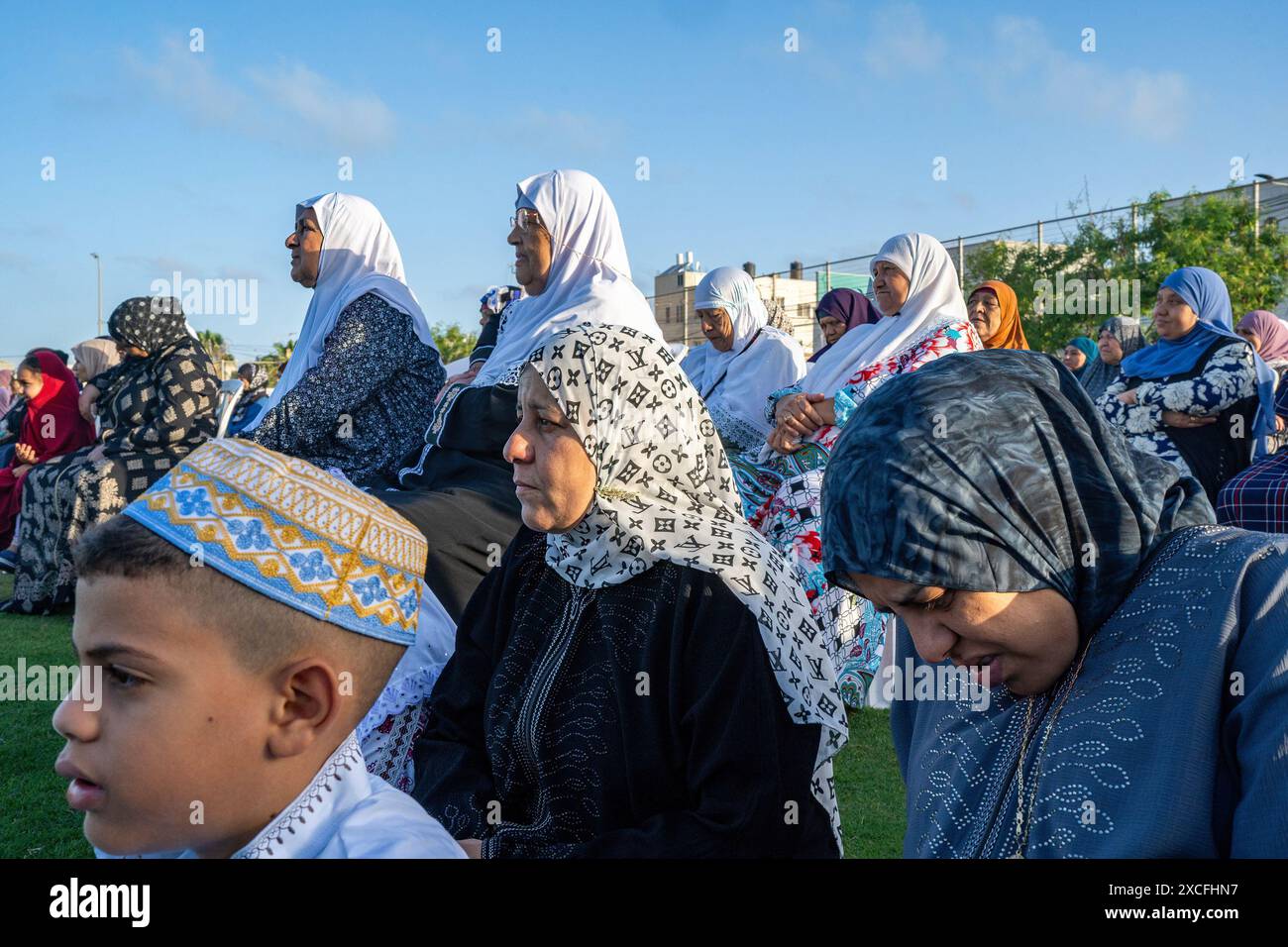 Donne e bambini musulmani hanno visto ascoltare la preghiera durante le celebrazioni di Eid al Adha. Le comunità musulmane in Israele celebrano l'importante festa Eid al Adha, nota anche come la "Festa del sacrificio". La festa commemora la volontà di Abramo di sacrificare suo figlio a Dio, secondo la tradizione musulmana. In questo giorno, la preghiera di Eid viene eseguita dopo l'alba, seguita da una visita al cimitero locale dove i fedeli rendono omaggio ai loro defunti familiari. Dopo la visita al cimitero, le famiglie tornano a casa ed eseguono il rituale del sacrificio del bestiame, di solito delle pecore, come simbolo Foto Stock