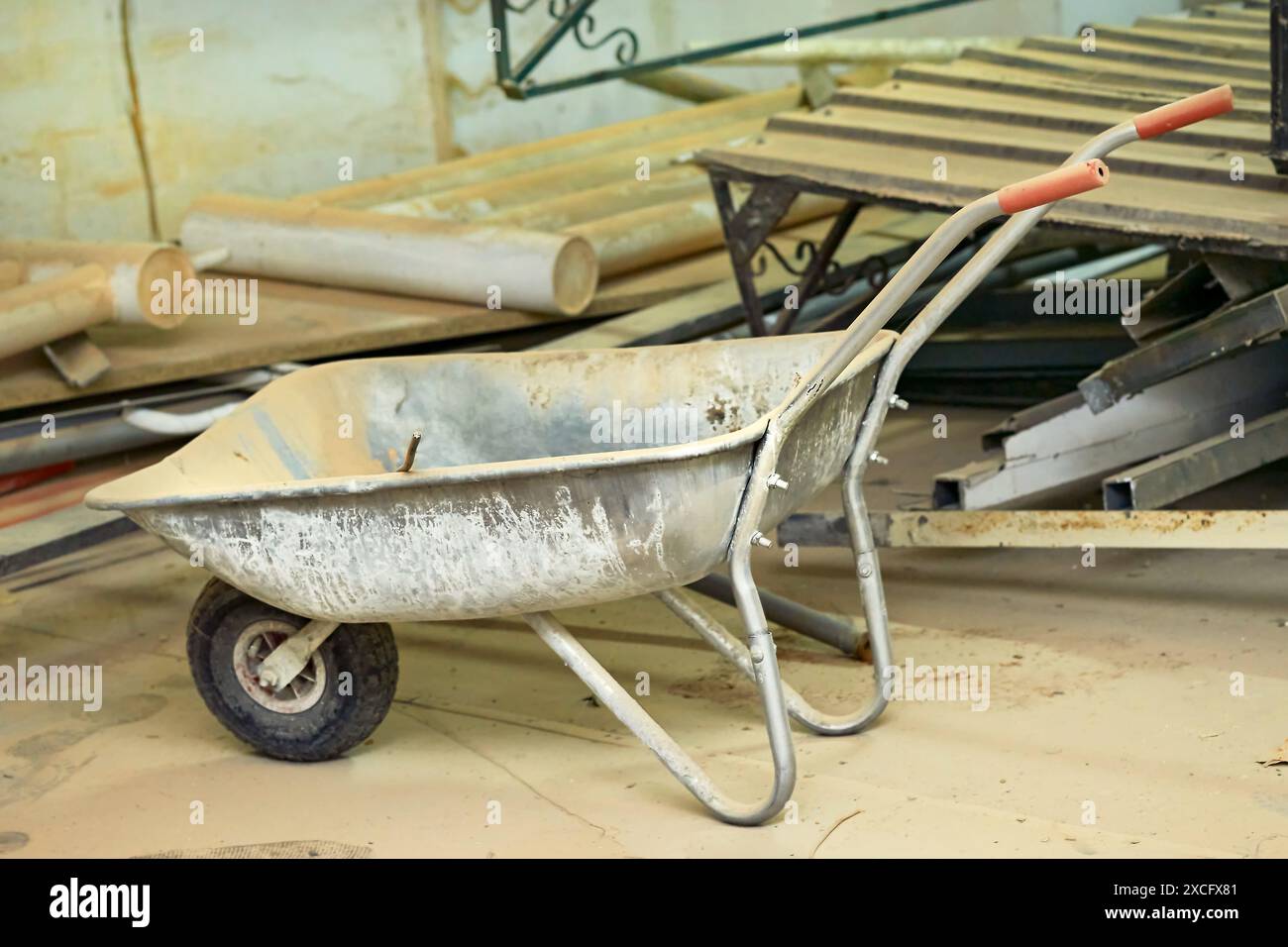 Carriola in metallo da costruzione, vari rifiuti dopo la riparazione Foto Stock