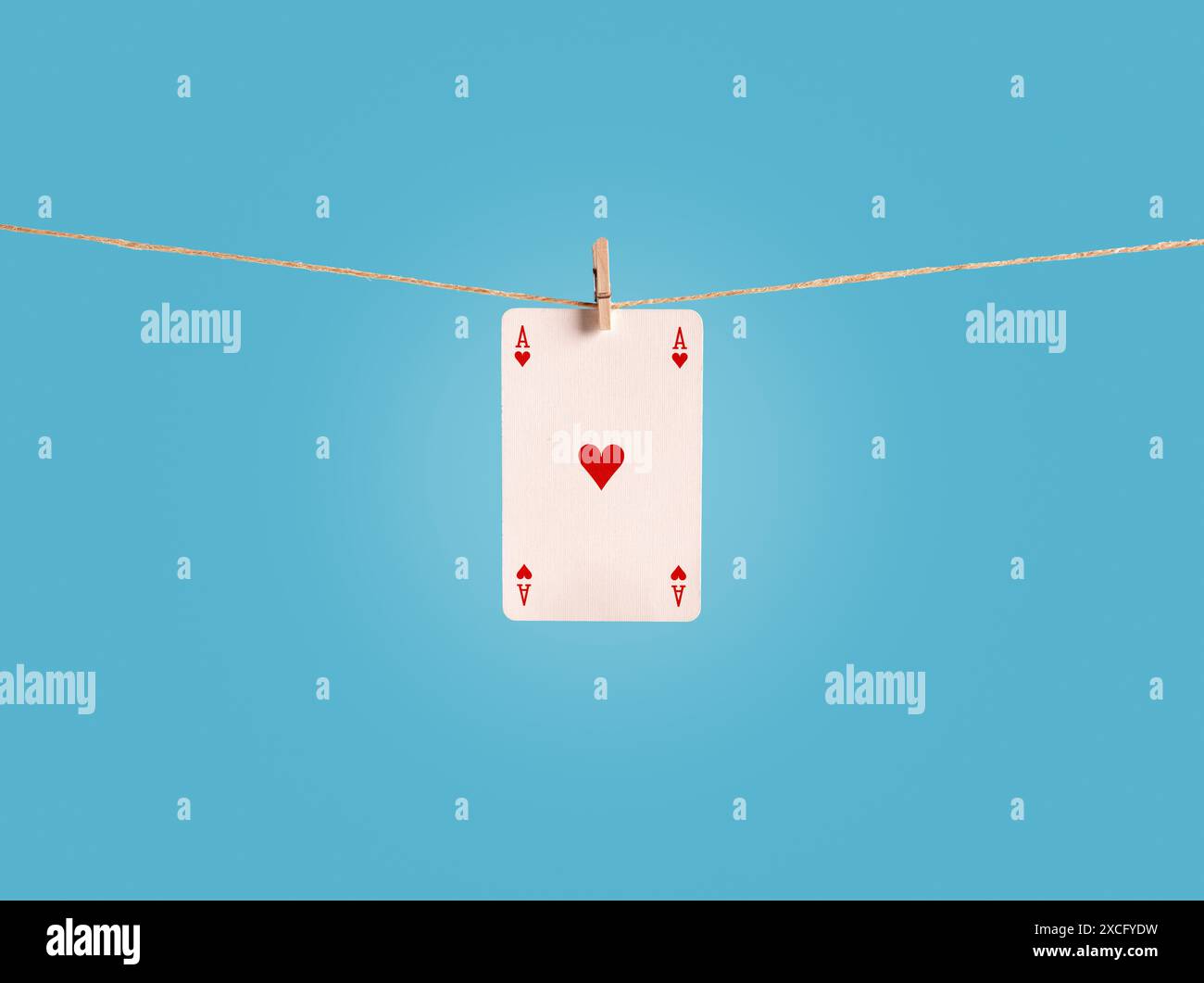 Gioco d'azzardo, fortuna e trovare un concetto di relazione romantica. La carta da gioco ACE of Hearts è appesa su una clothesline con una clothespin Foto Stock
