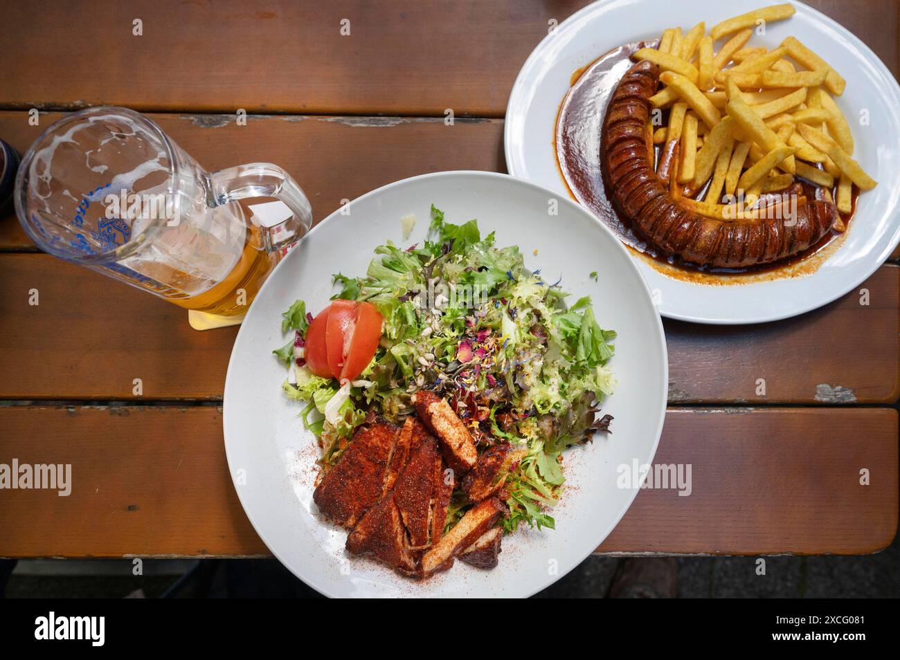 Insalata con strisce di tacchino e currywurst con patatine fritte servita in giardino, Baviera, Germania Foto Stock