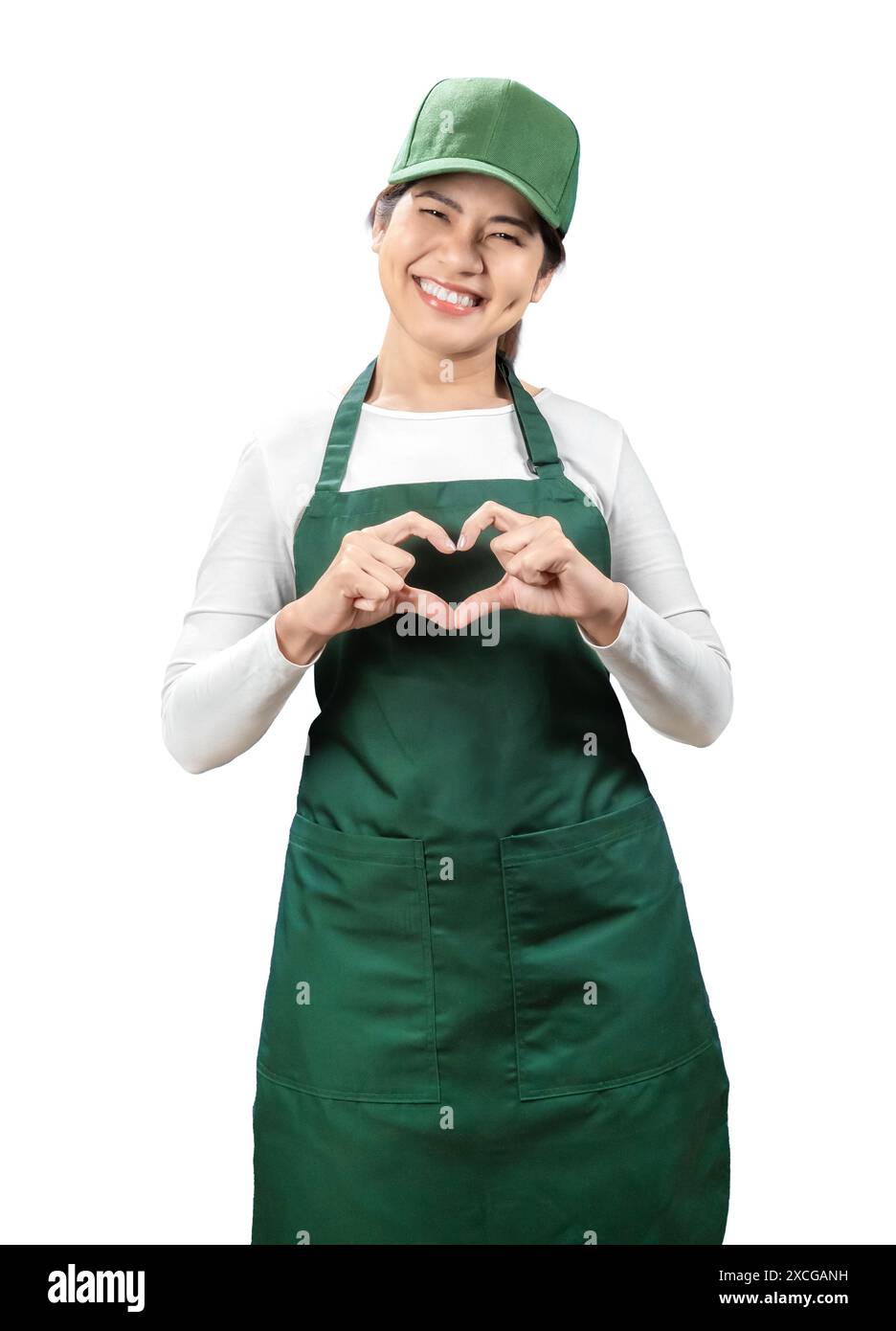 I venditori asiatici indossano un grembiule verde e un berretto verde sorridenti e mostrano segni cardiaci isolati sul bianco Foto Stock