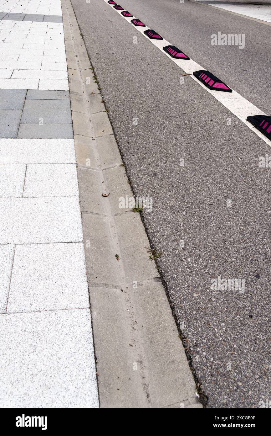 Pista ciclabile vuota con segnaletica bianca restrittiva e segnaletica a semaforo rosso su una strada della città da vicino Foto Stock