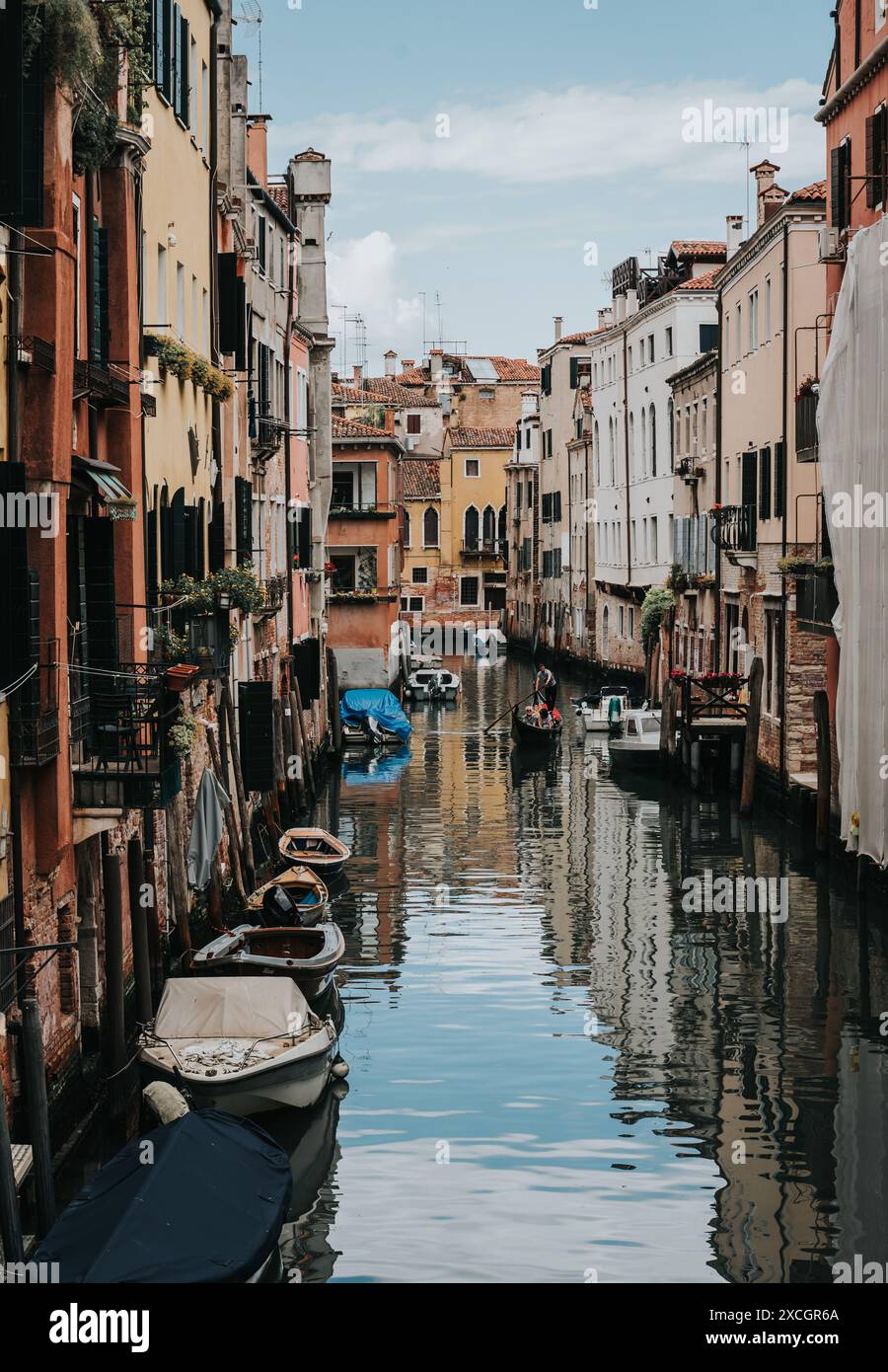 Vista del tranquillo e stretto canale con la gondola a Venezia. Foto Stock