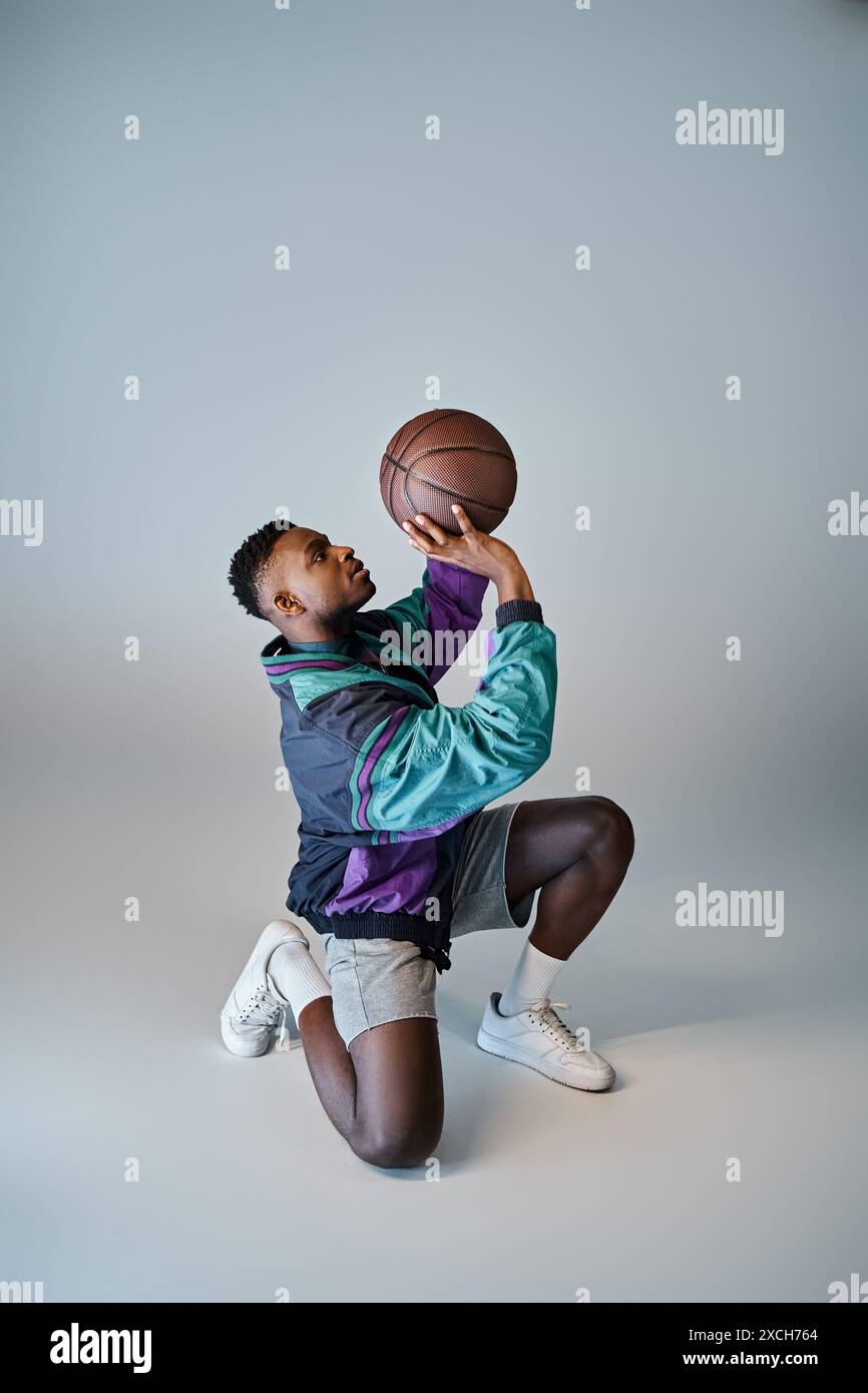 Un elegante cestista afroamericano si accosta per prendere una palla. Foto Stock