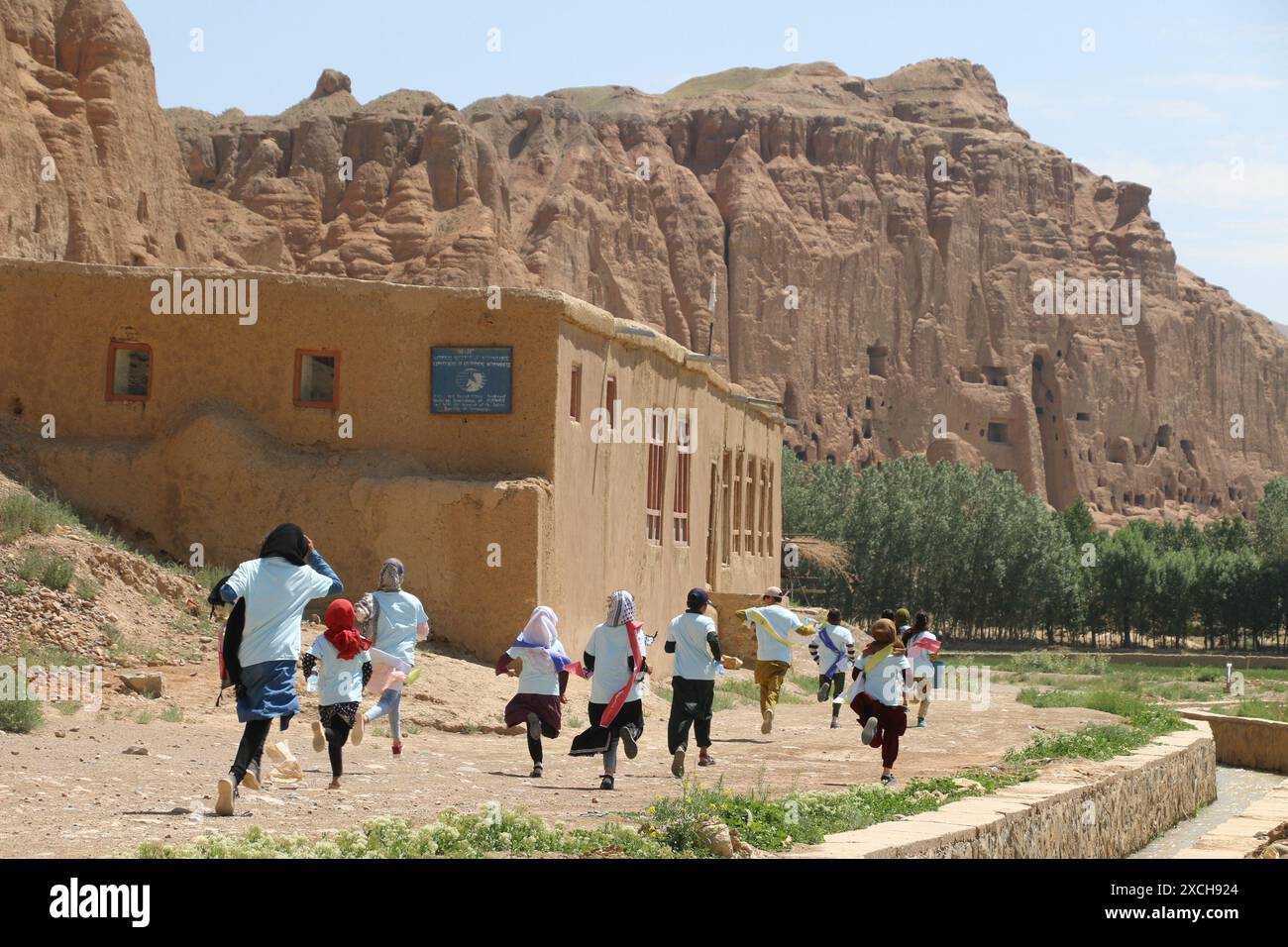 Bamiyan. 15 giugno 2024. Questa foto scattata il 15 giugno 2024 mostra una mini-maratona mirata a sensibilizzare il locale sull'urgente necessità di proteggere le reliquie culturali nella provincia di Bamiyan, Afghanistan centrale. ANDARE CON "Feature: I bambini afghani corrono per la protezione del patrimonio culturale in mini-maratona". Crediti: Ziaodin Azad/Xinhua/Alamy Live News Foto Stock