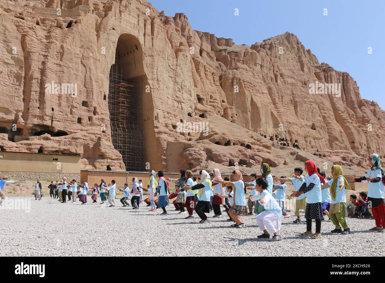 Bamiyan, Afghanistan. 15 giugno 2024. I bambini afghani della valle di Bamiyan si riscaldano prima di una mini-maratona mirava a sensibilizzare il locale sull'urgente necessità di proteggere le reliquie culturali nella provincia di Bamiyan, Afghanistan centrale, il 15 giugno 2024. ANDARE CON "Feature: I bambini afghani corrono per la protezione del patrimonio culturale in mini-maratona". Crediti: Ziaodin Azad/Xinhua/Alamy Live News Foto Stock