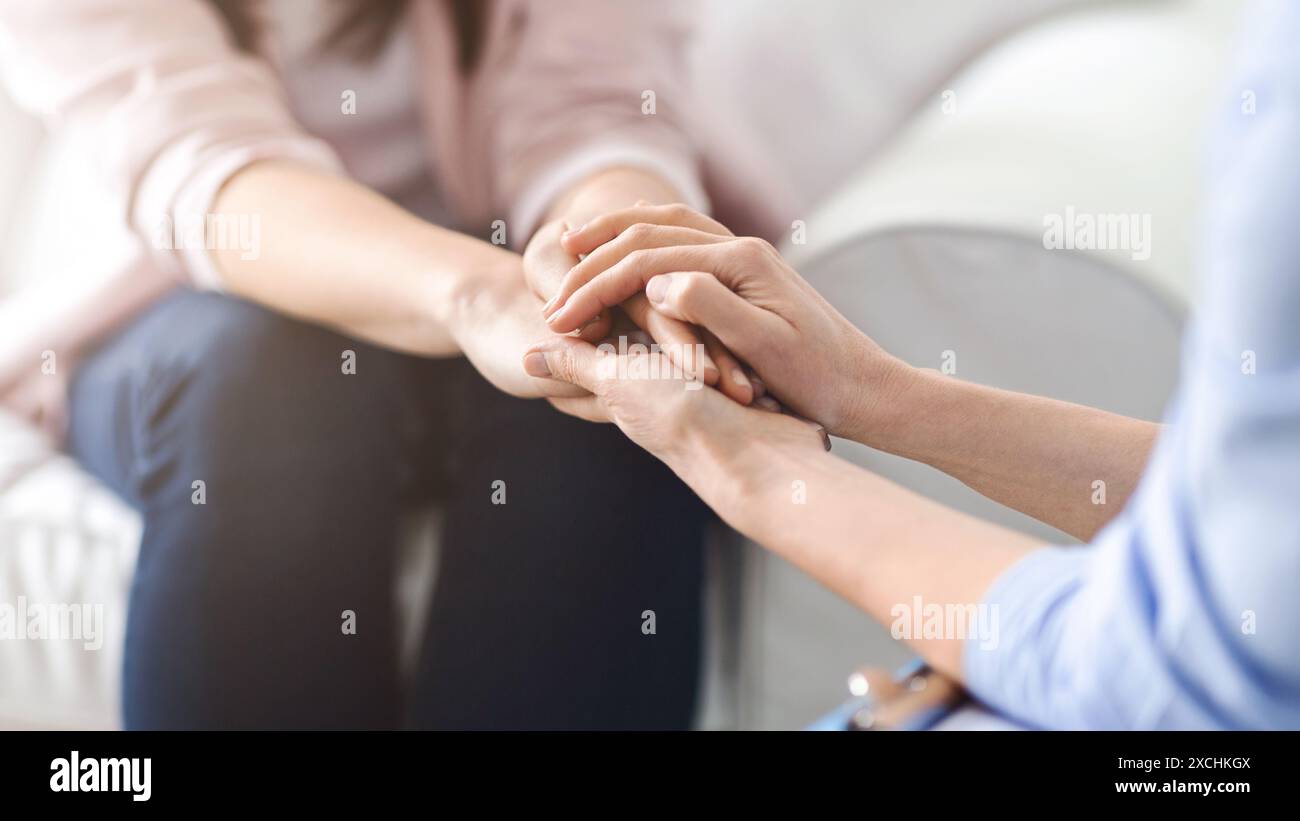 Due donne che offrono supporto emotivo con mano Foto Stock