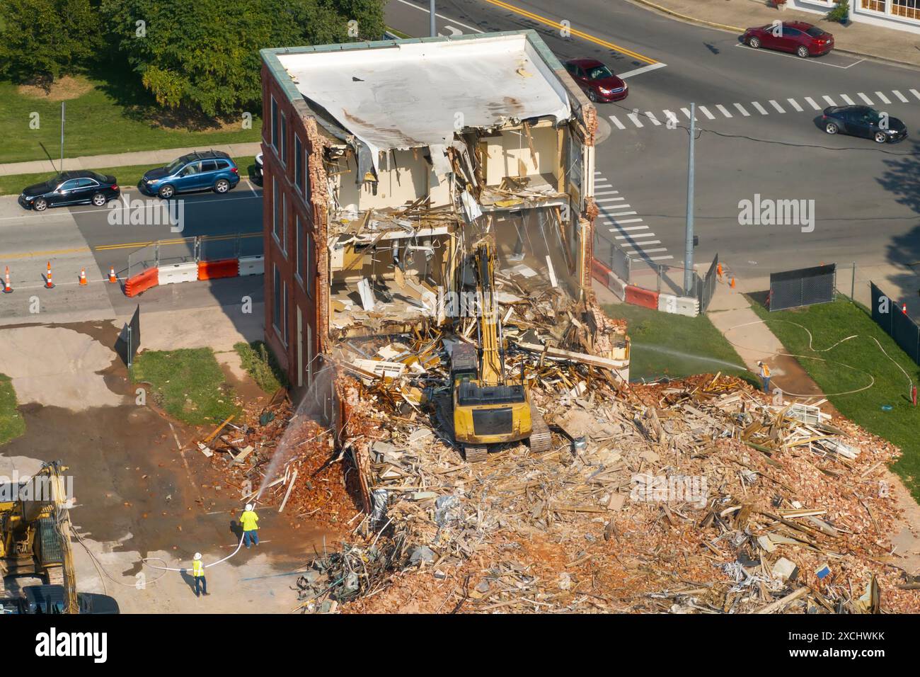 Demolizione dello storico edificio Edwards a Berea, Kentucky. Escavatore cingolato che demolisce pareti in mattoni di vecchia struttura Foto Stock