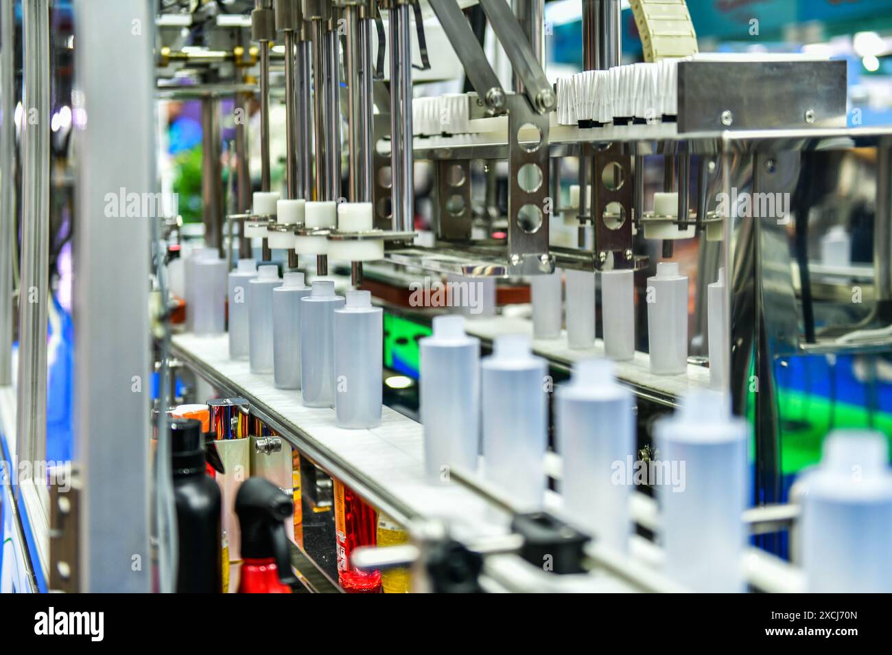 Bottiglie di plastica bianche in un nastro trasportatore su una macchina di riempimento verticale automatica di alta qualità. nella linea di produzione della fabbrica Foto Stock