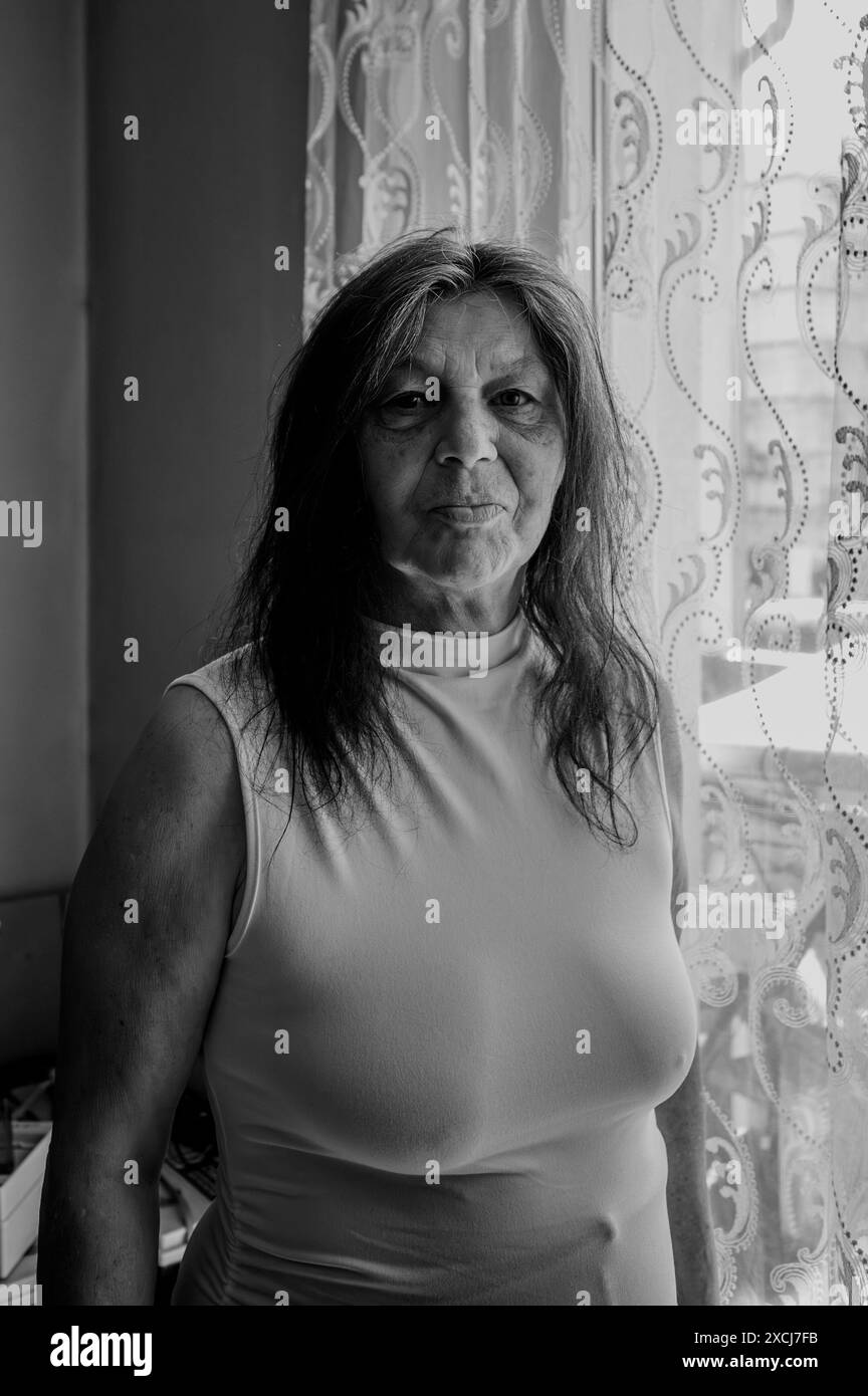 Donna più anziana alla finestra Foto Stock