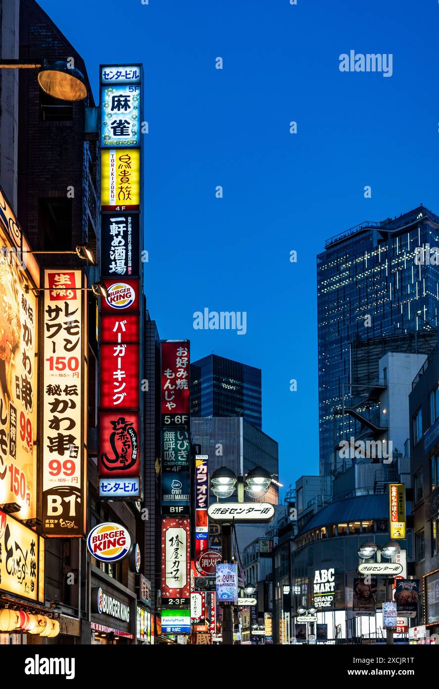 Un assaggio del famoso quartiere di Shibuya di notte, con grattacieli, luci, negozi di cartelloni e cartelloni, Tokyo, Giappone Foto Stock