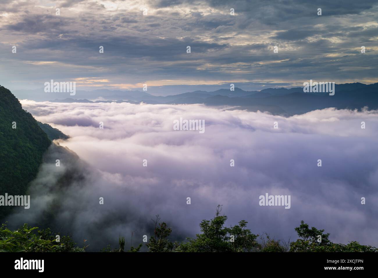 La luce del sole fa cambiare imprevedibilmente il mare delle nuvole, come le onde tempestose. Vista sulle montagne che circondano Emerald Reservoir. Distretto di Xindian, T. Foto Stock