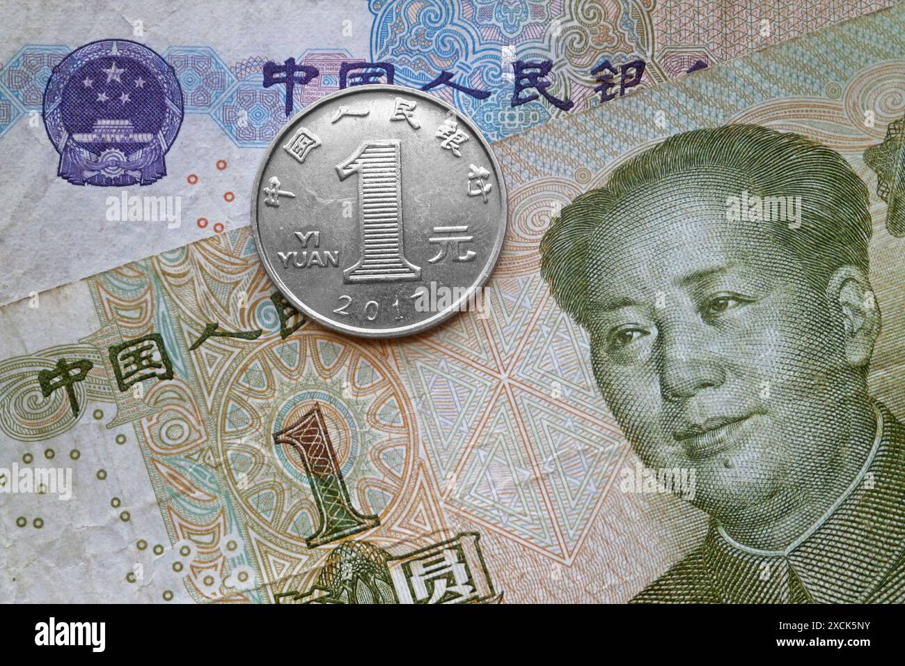 Una moneta da 1 yuan sopra una banconota da 1 yuan e una banconota da 5 yuan. Foto Stock