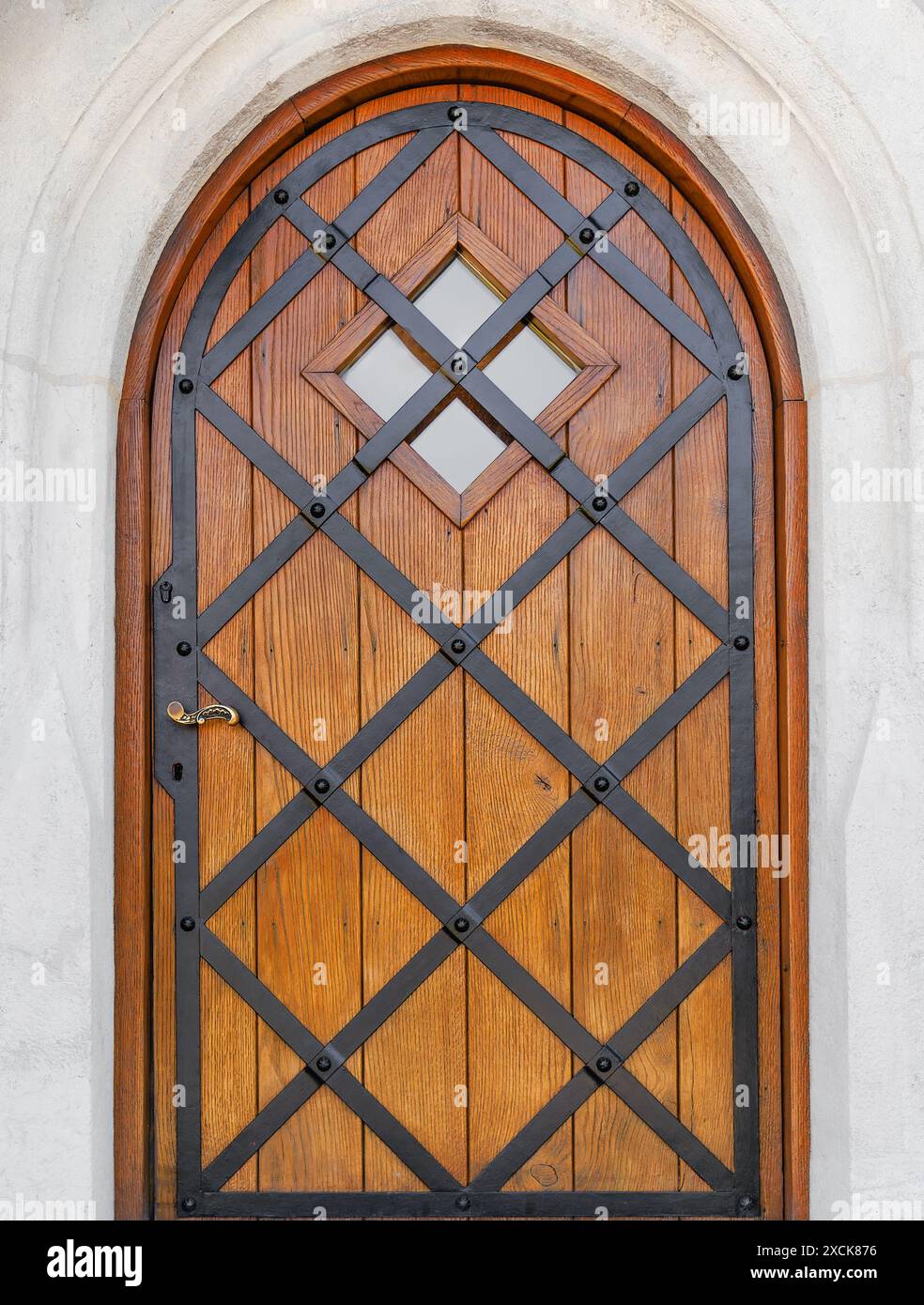 Splendida porta d'ingresso di un edificio storico. La porta ha una forma ad arco. La porta è realizzata in legno laccato dorato. Foto Stock