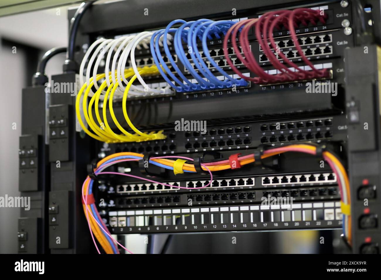 Rack dati di rete con primo piano delle apparecchiature di rete montate. Patch cord e patch panel. Messa a fuoco selettiva. Foto Stock